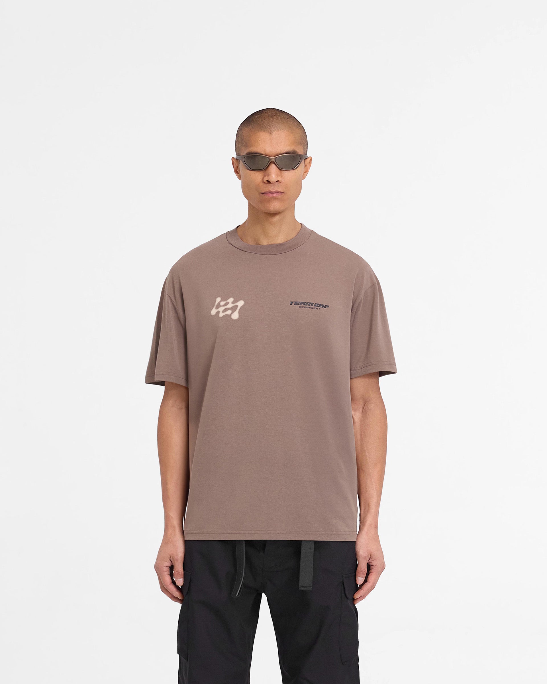 Man wearing an oversized umber t-shirt on a plain white background | 247 Future Terrains Oversized T-Shirt in Umber | Lightweight quick drying t-shirt | 247 T-Shirts | Represent Clo