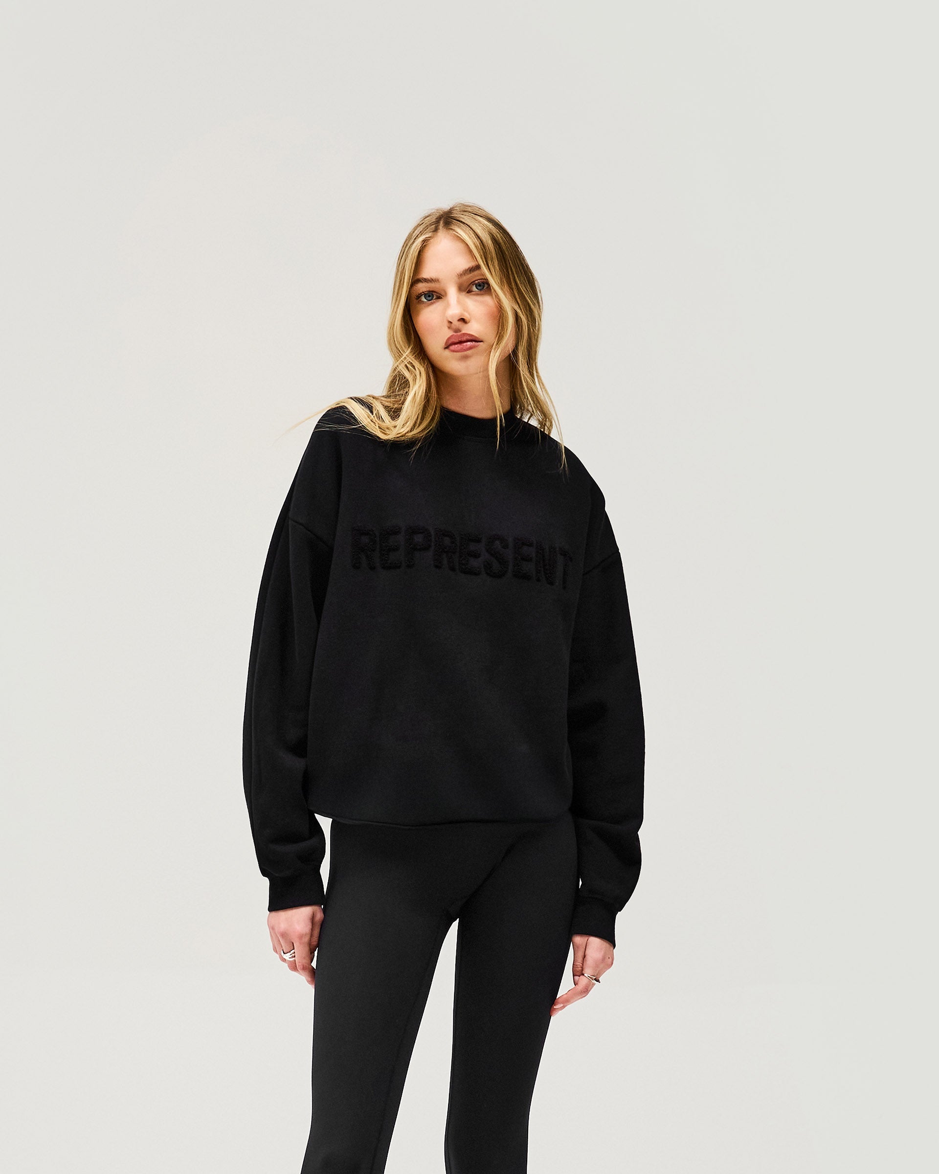 Back product image of a womens black sweater on a plain white background | Owners Club Sweater in Jet Black | Sweater with set in sleeves and embroidered branding | Womens Owners Club Sweaters | Represent Clo