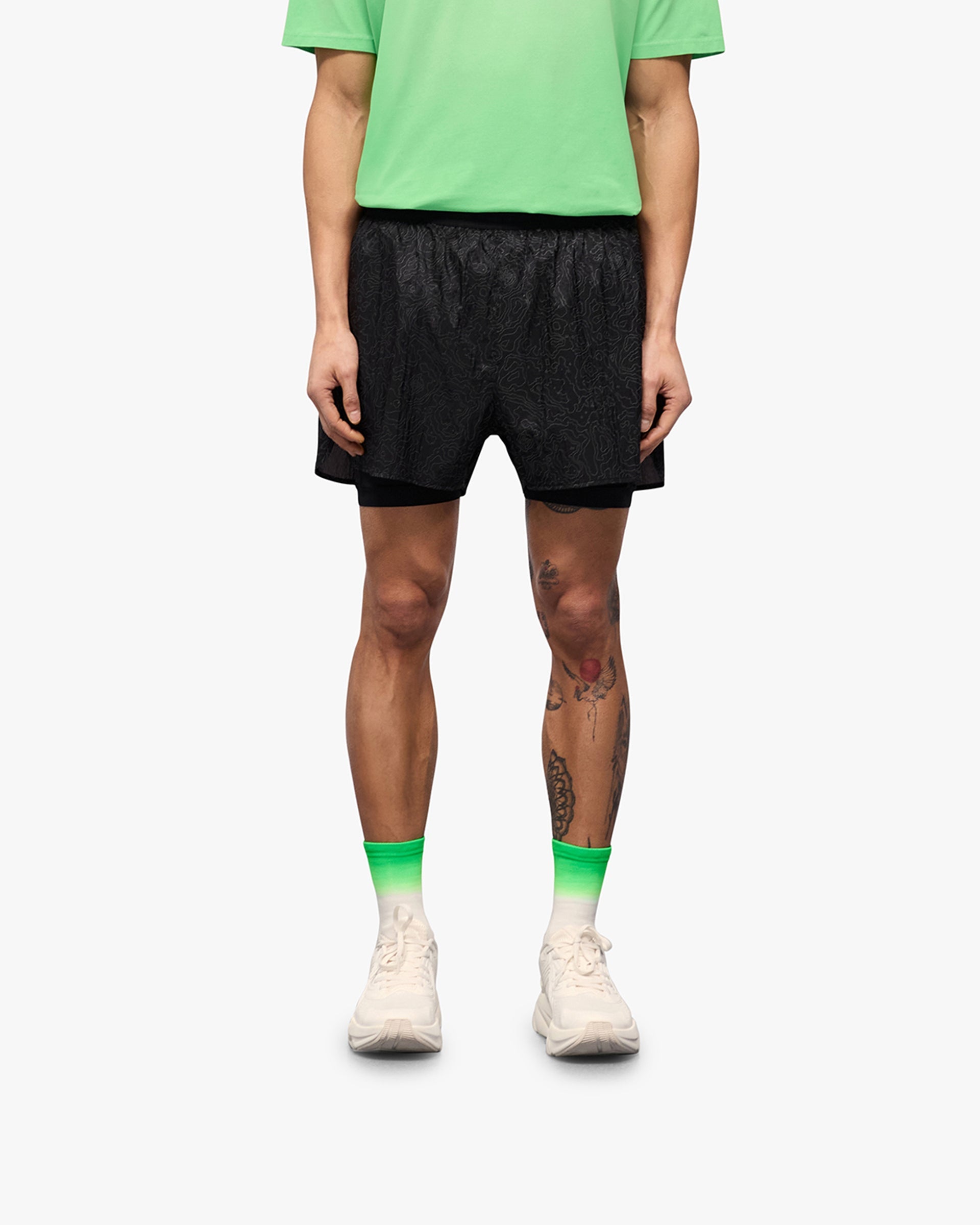 Man wearing black running shorts on a plain white background | 247 Contour 2 In 1 Run Shorts in Black | Running shorts with inner leggings and zip pockets | 247 Shorts | Represent Clo