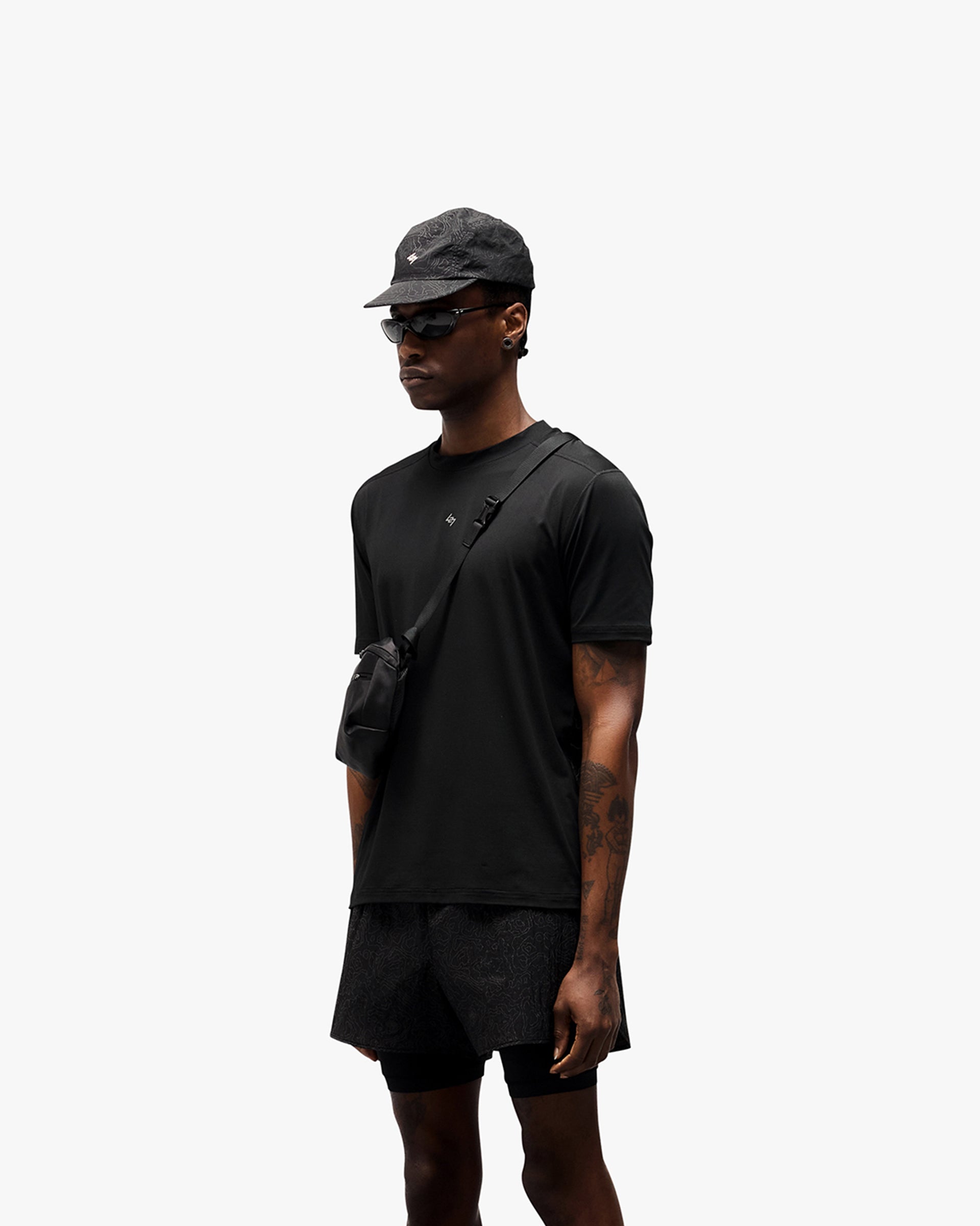 Man wearing a black t-shirt with reflective contour print on a plain white background | 247 Contour Run T-Shirt in Black | Breathable running t-shirt with antibacterial finish | 247 T-Shirts | Represent Clo