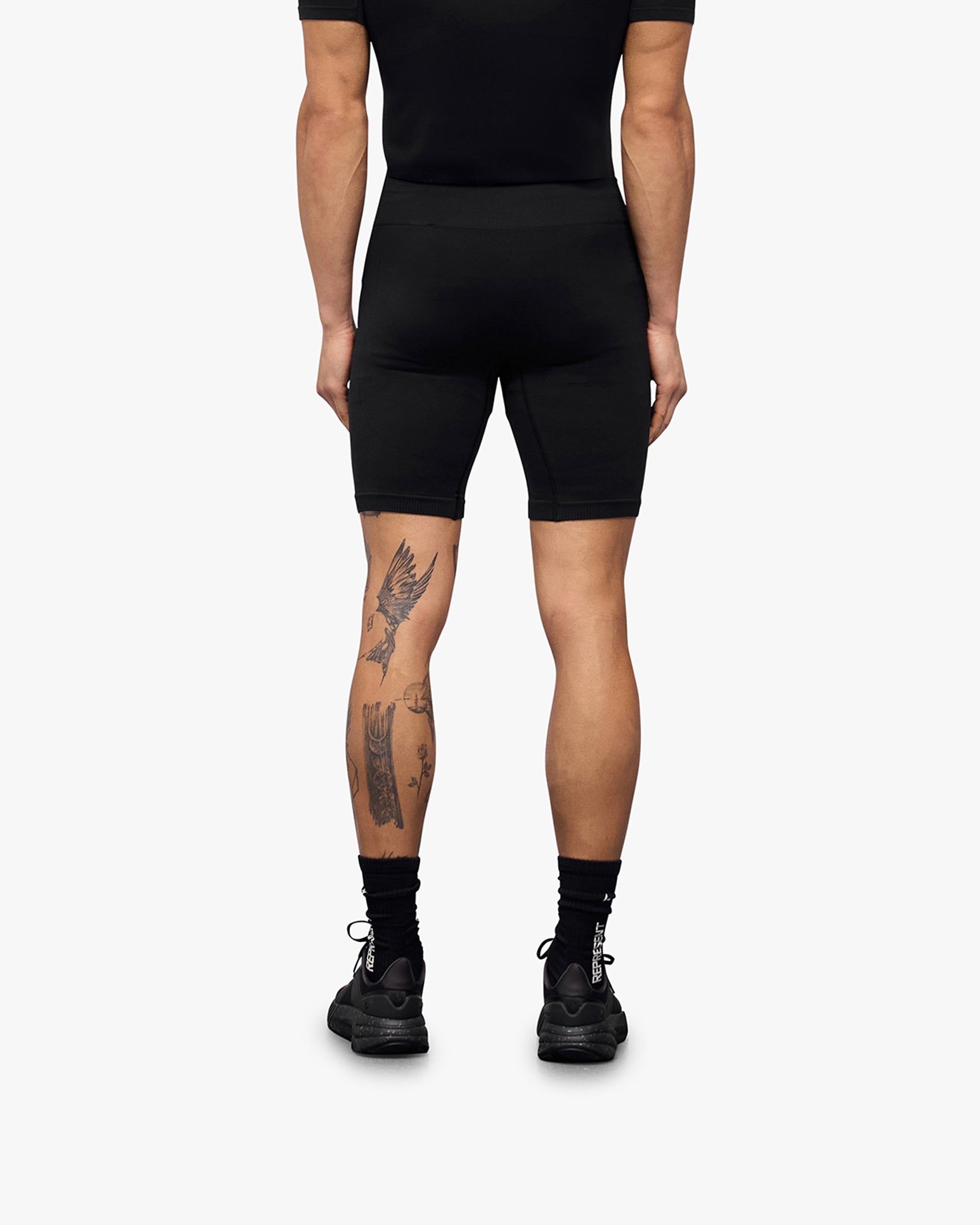 Man wearing black seamless shorts on a plain white background | 247 DNA Seamless Shorts in Black | Seamless shorts with compression support | 247 Shorts | Represent Clo
