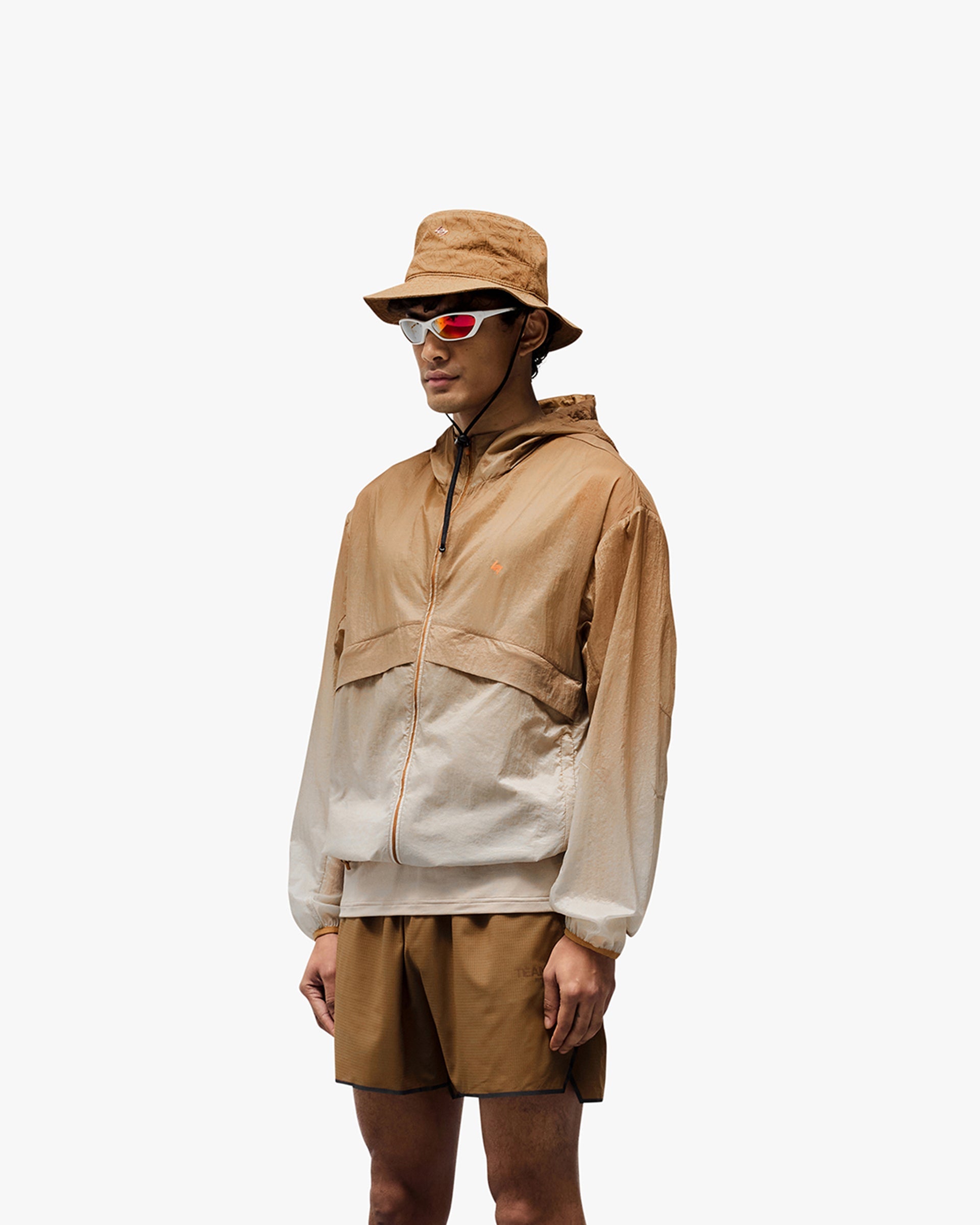Man wearing an ombre training jacket on a plain white background | 247 Hooded Training Jacket in Ombre | Hooded outerwear with DWR coating and adjustable hem | 247 Outerwear | Represent Clo