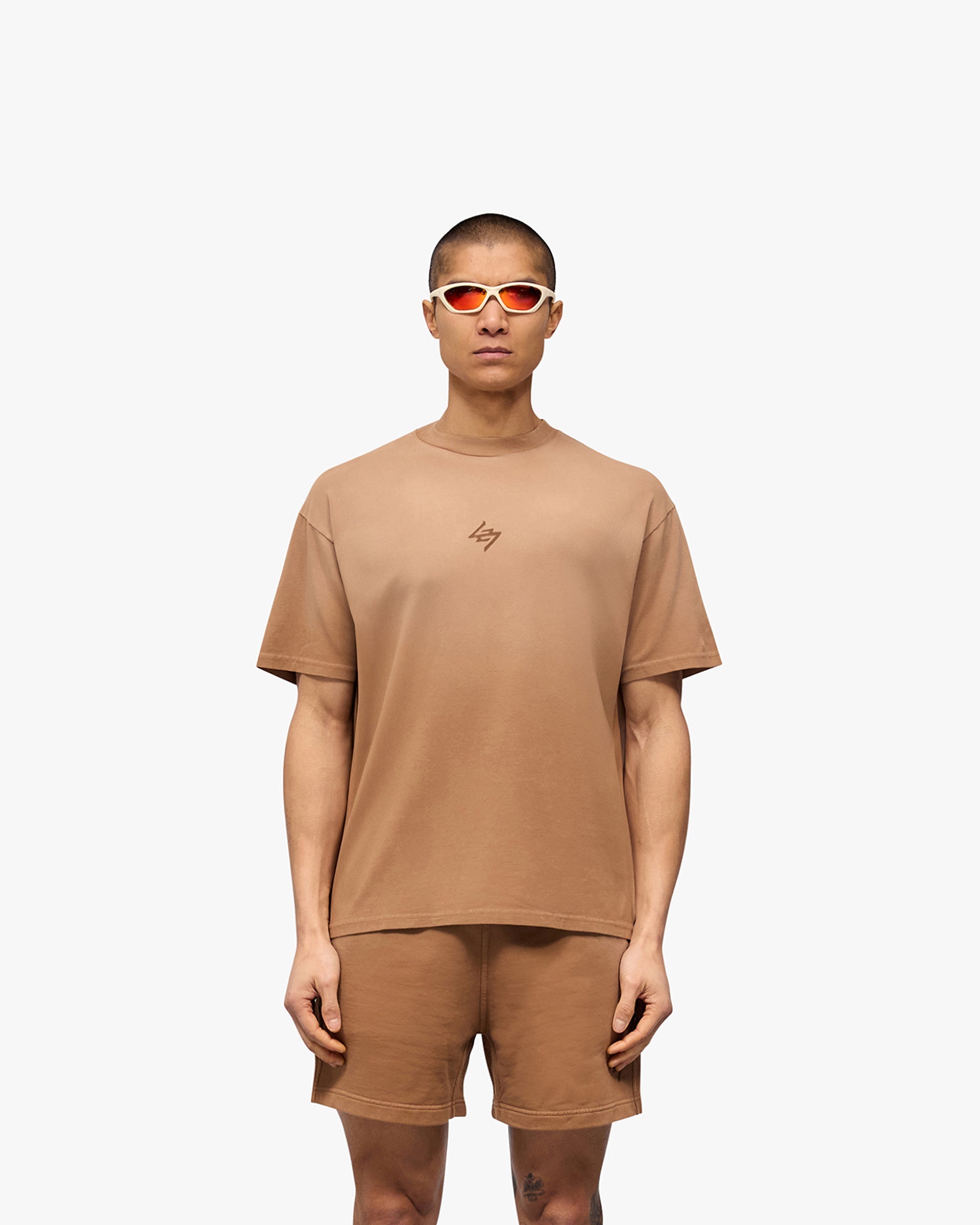 Man wearing a rust oversized t-shirt on a plain white background | 247 Motion Oversized T-Shirt in Rust | T-Shirt with stretch and graphic print | 247 T-Shirts | Represent Clo