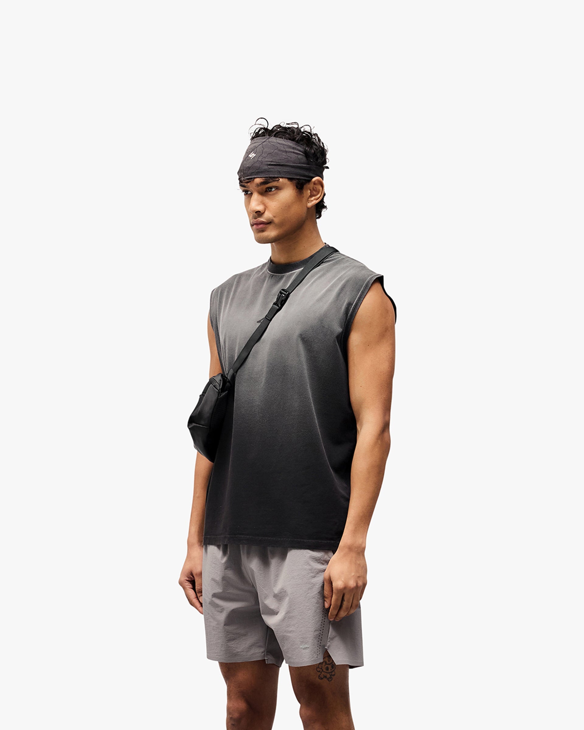 Man wearing an aged black tank top on a plain white background | 247 Motion Oversized Tank in Aged Black | Oversized tank with fade out wash and water based graphic | 247 T-Shirts | Represent Clo