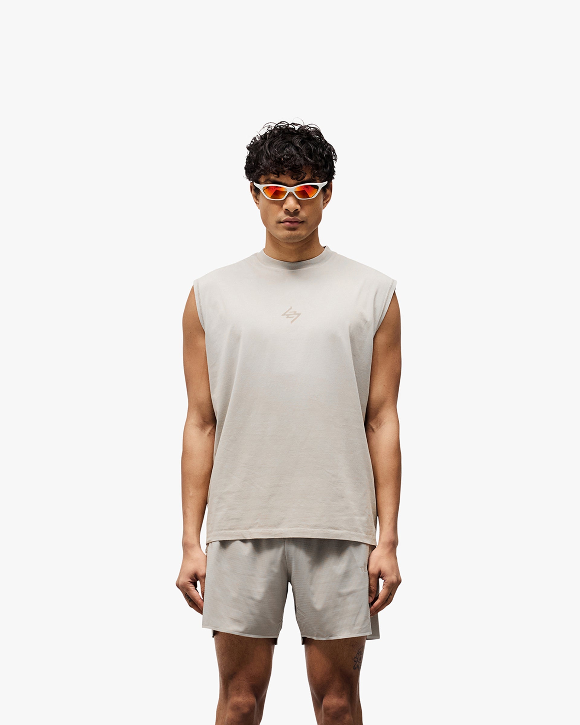 Man wearing a grey oversized tank on a plain white background | 247 Motion Oversized Tank in Pebble | Oversized tank with 2 way stretch and water based graphic print | 247 T-Shirts | Represent Clo