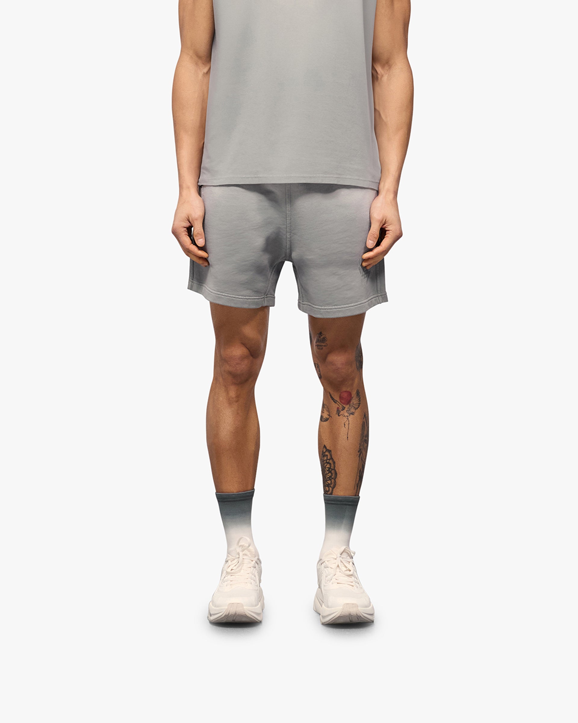Man wearing grey shorts on a plain white background | 247 Motion Shorts in Titanium | Jersey shorts with elasticated waistband and drawcord | 247 Shorts | Represent Clo