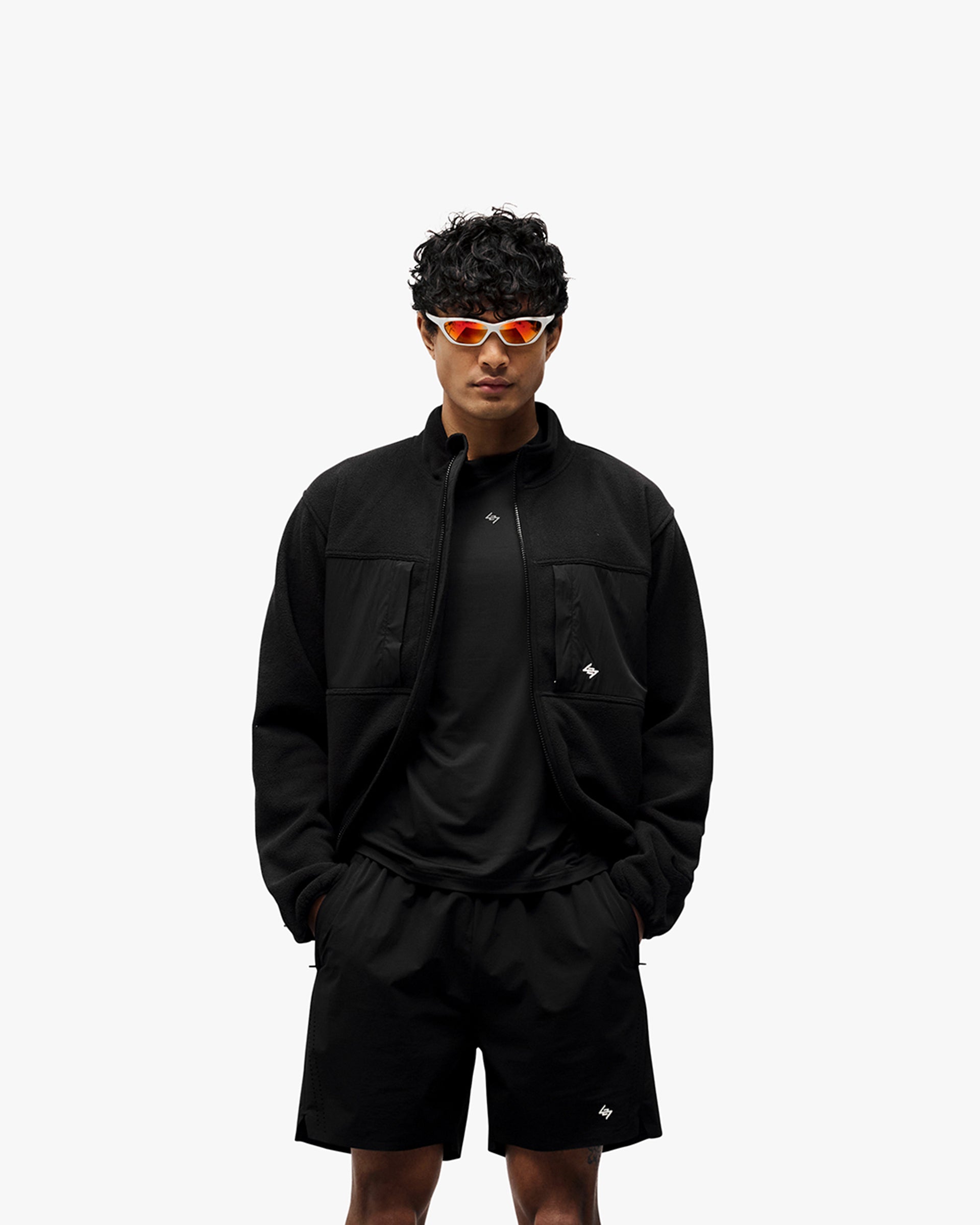 Man wearing a black fleece on a plain white background | 247 Polar Panelled Fleece in Black | Fleece with double-ended zip and toggle hem | 247 Outerwear | Represent Clo