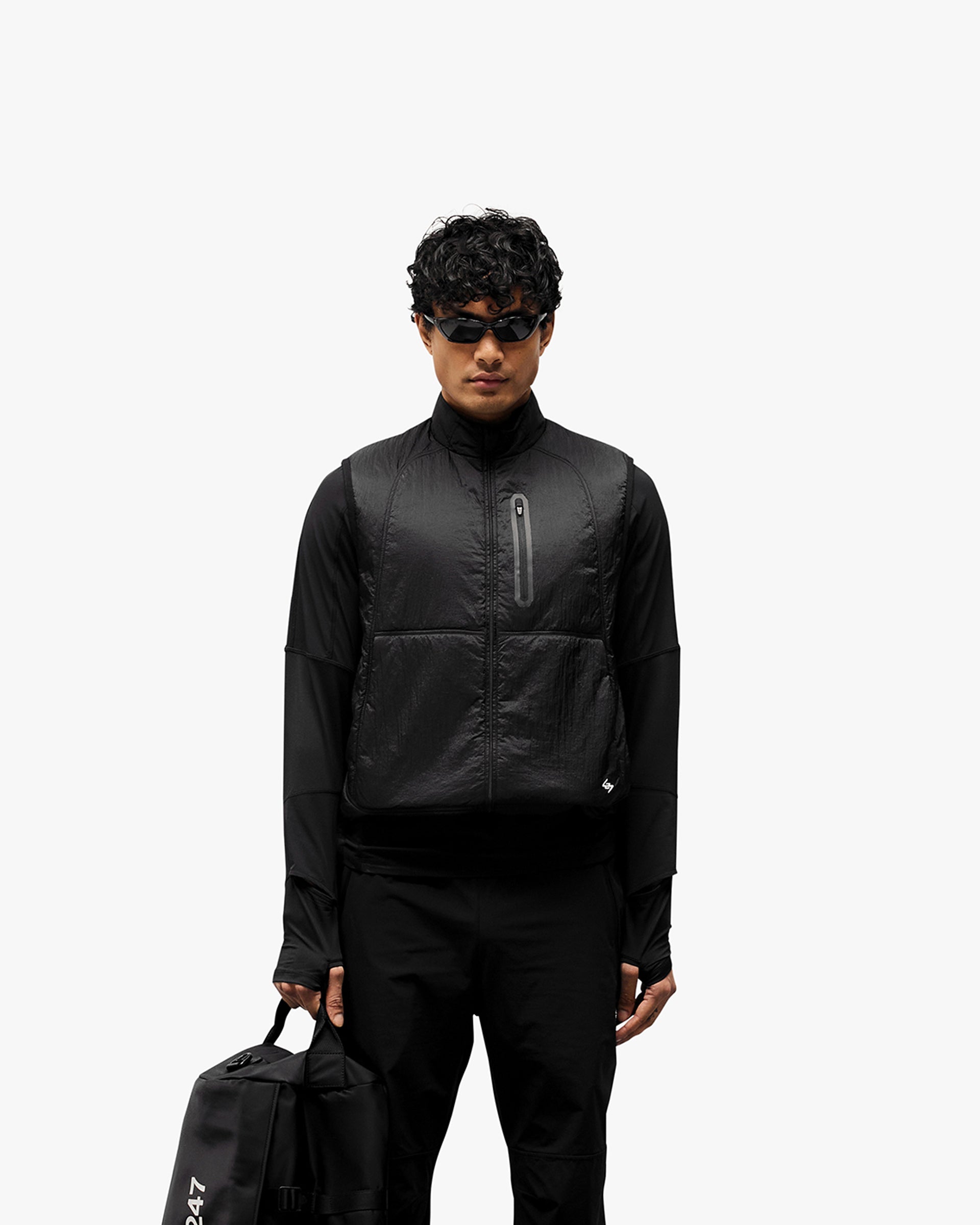 Man wearing a black running gilet on a plain white background | 247 Run Gilet in Black | Running gilet with insulation and zip pockets | 247 Outerwear | Represent Clo