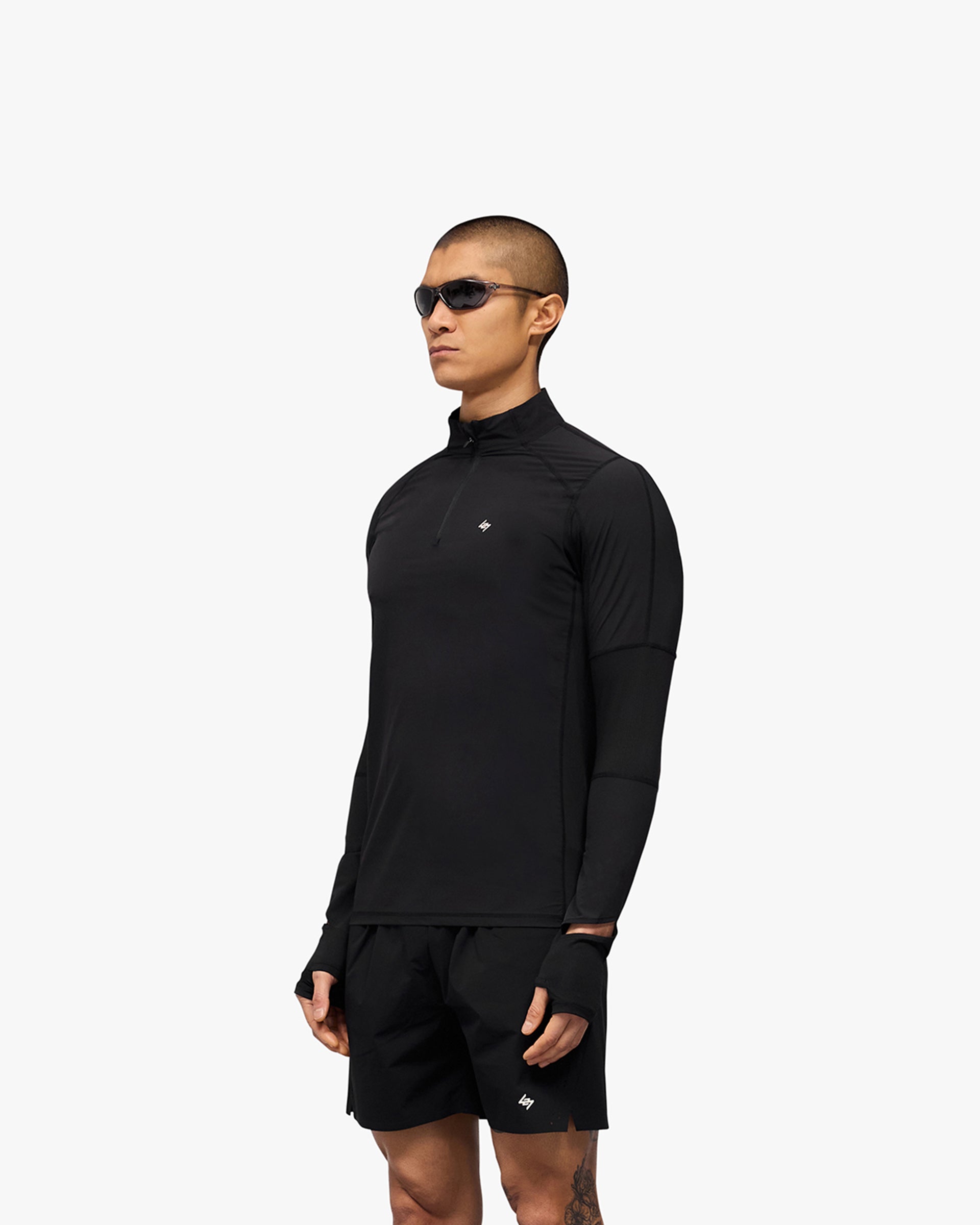 Man wearing a black quarter zip jacket on a plain white background | 247 Run Quarter Zip in Jet Black | Nylon blend outerwear with mesh panels | 247 Outerwear | Represent Clo