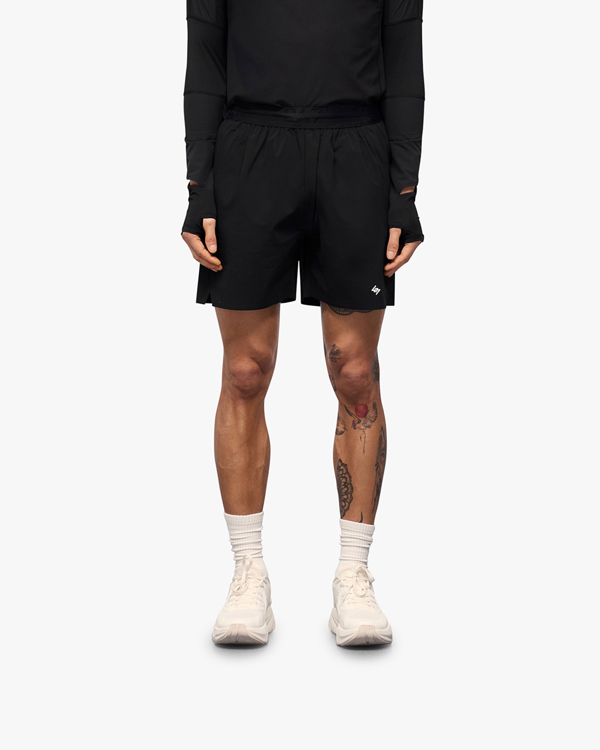 Man wearing black training shorts on a plain white background | 247 Training Shorts in Black | Shorts with perforation detailing and zip pockets | 247 Shorts | Represent Clo