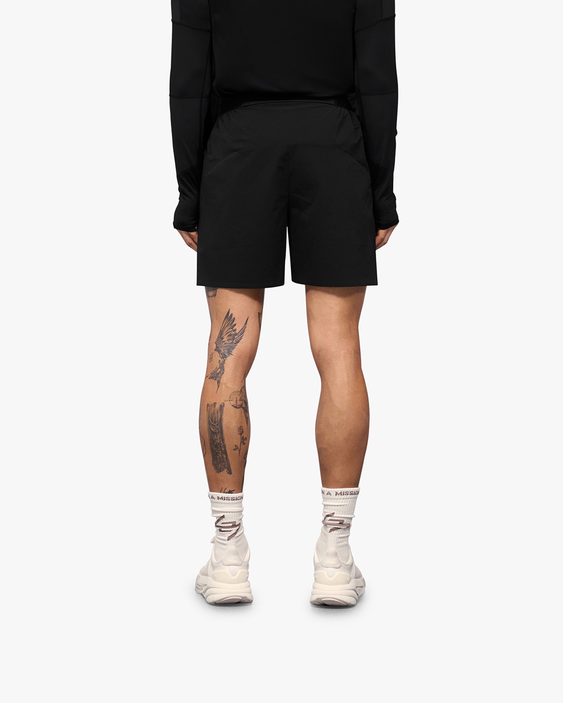 Man wearing black training shorts on a plain white background | 247 Training Shorts in Black | Nylon blend shorts with perforation detailing | 247 Shorts | Represent Clo