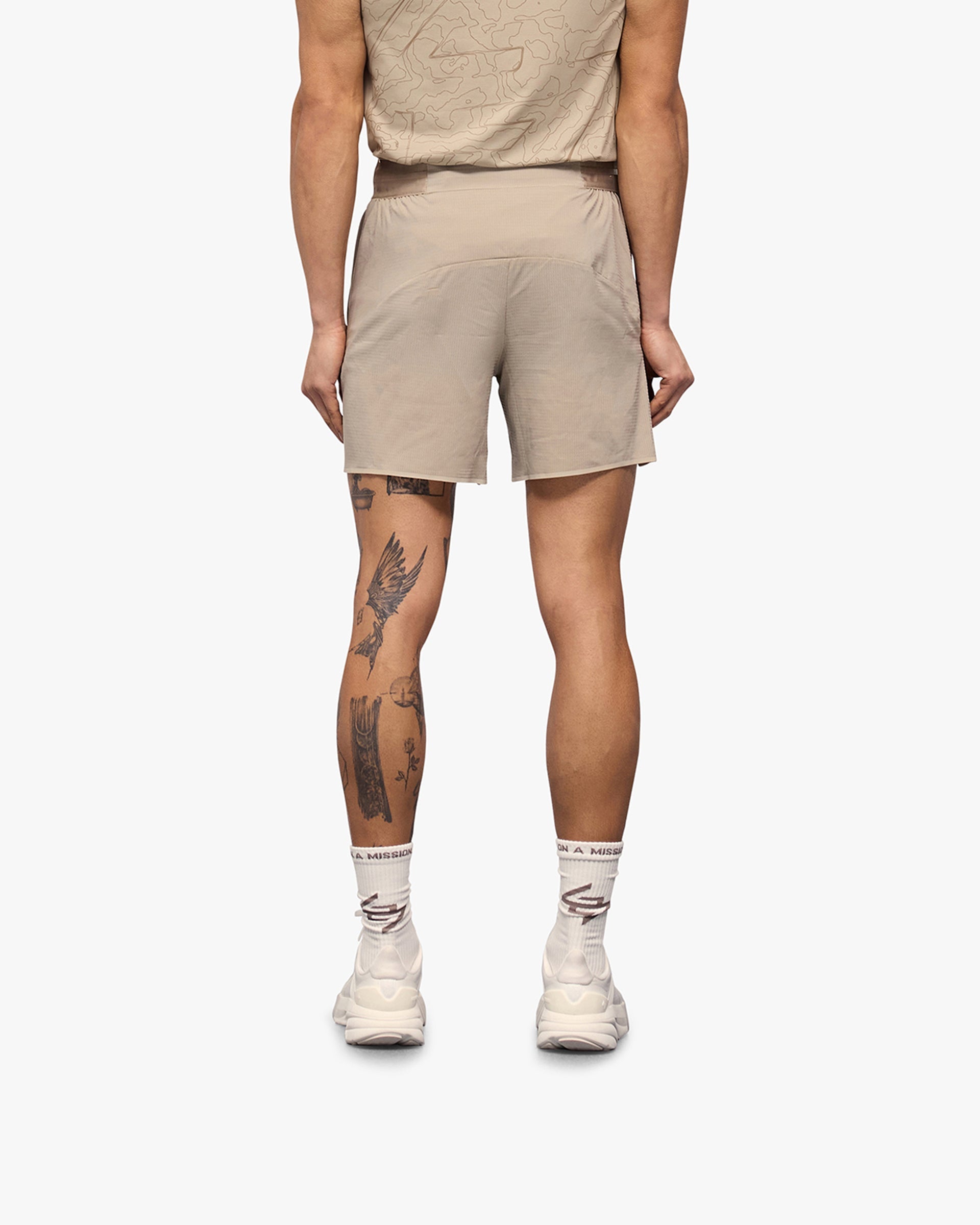 Man wearing grey shorts on a plain white background | Team 247 Aero Shorts in Pebble | Lightweight breathable running shorts | 247 Shorts | Represent Clo