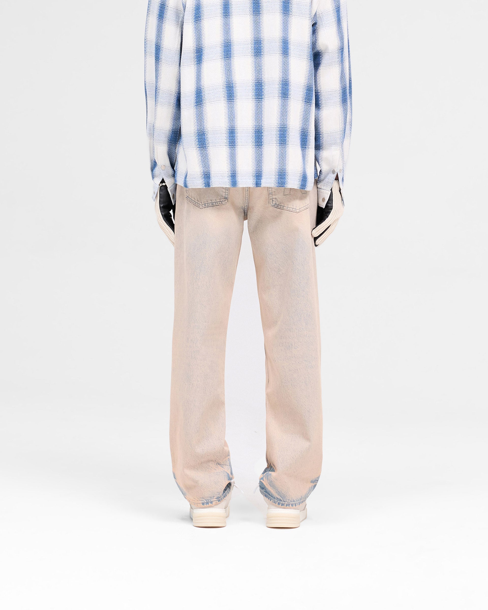 Man wearing baggy blue denim jeans on a plain white background | R3 Baggy Denim in Dusk | Baggy fit heavy wash denim jeans | SS25 Denim | Represent Clo