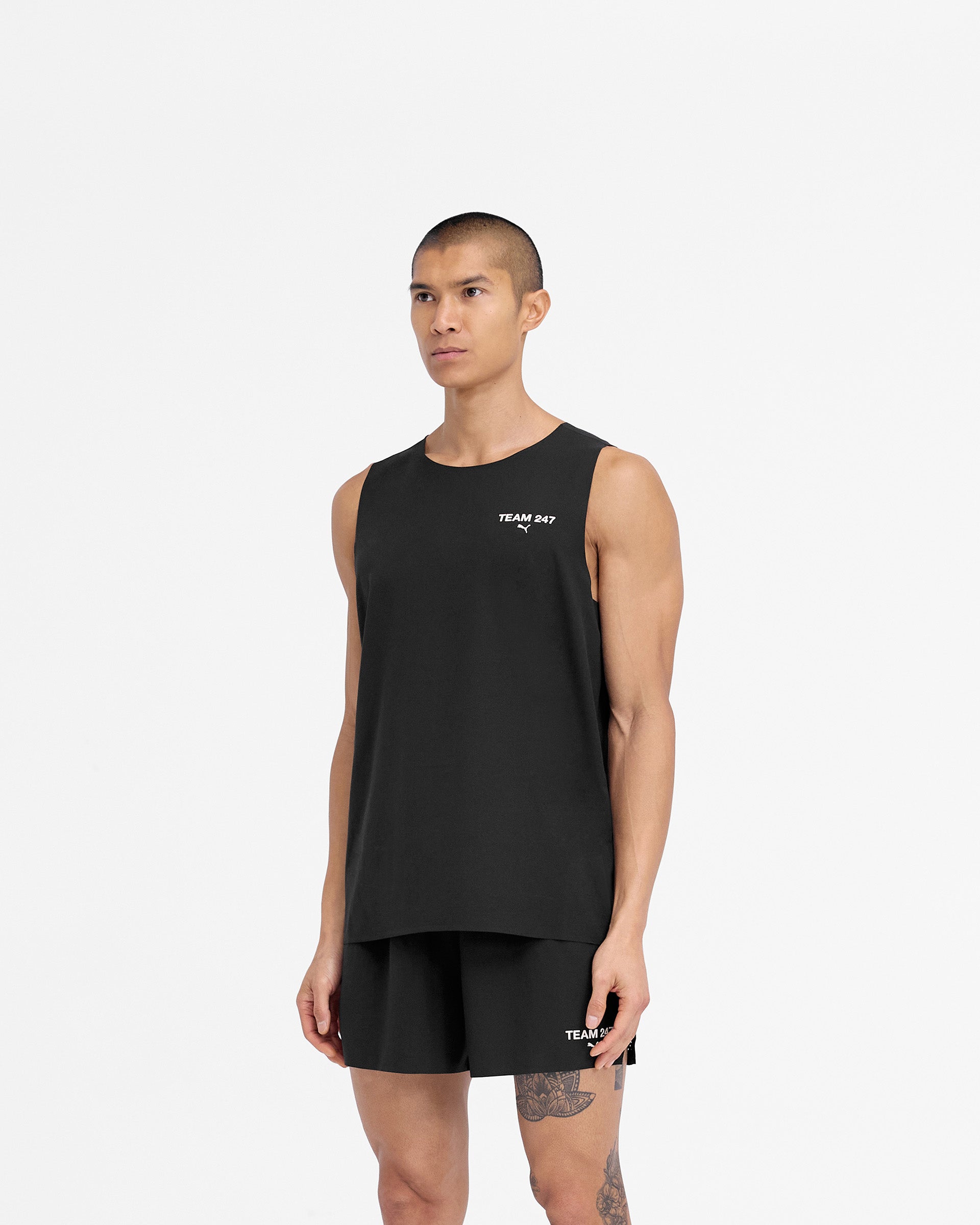 Man wearing a black oversized tank on a plain white background | 247 X Puma Oversized Tank in Black | Lightweight tank with 3D branding | 247 T-Shirts | Represent Clo