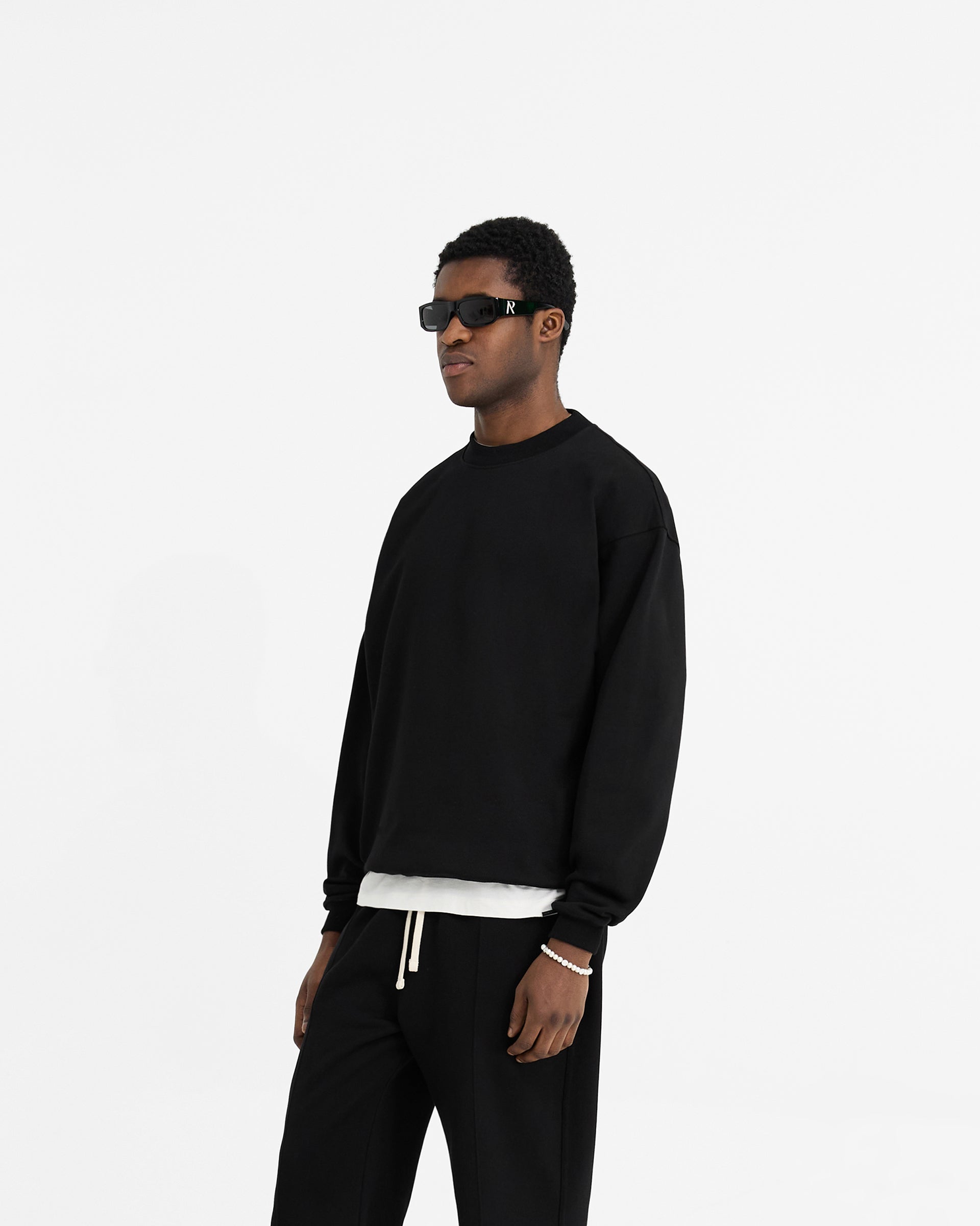 Back product image of a mens black sweater on a plain white background | Initial Oversized Sweater in Black | Oversized fit with embroidered Initial and metal bar | Initial Sweaters | Represent Clo