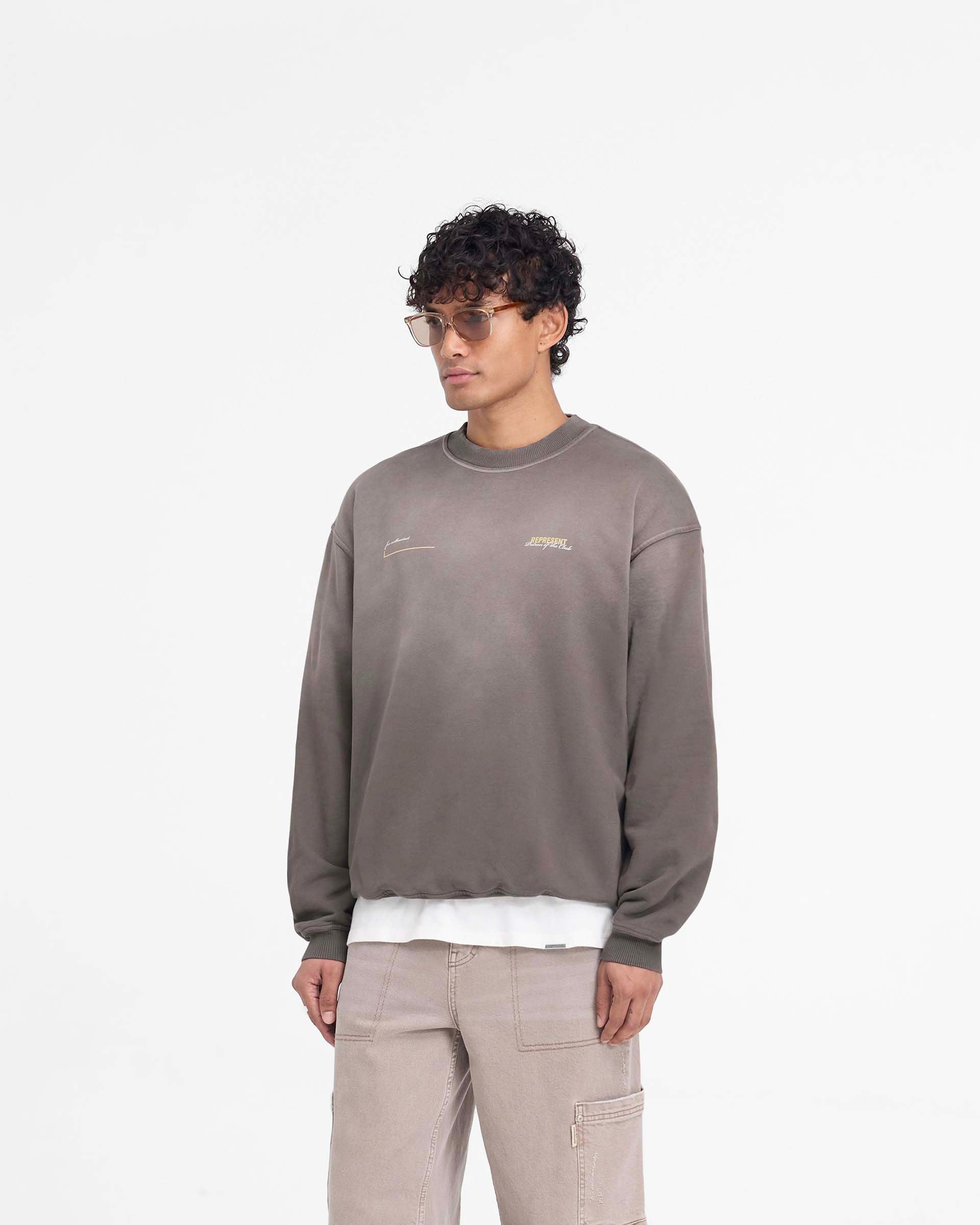 Man wearing an oversized green sweater on a plain white background | Patron Of The Club Sweater in Washed Olive | Oversized fit sweater with ribbed hem and cuffs | Patrons Sweaters | Represent Clo