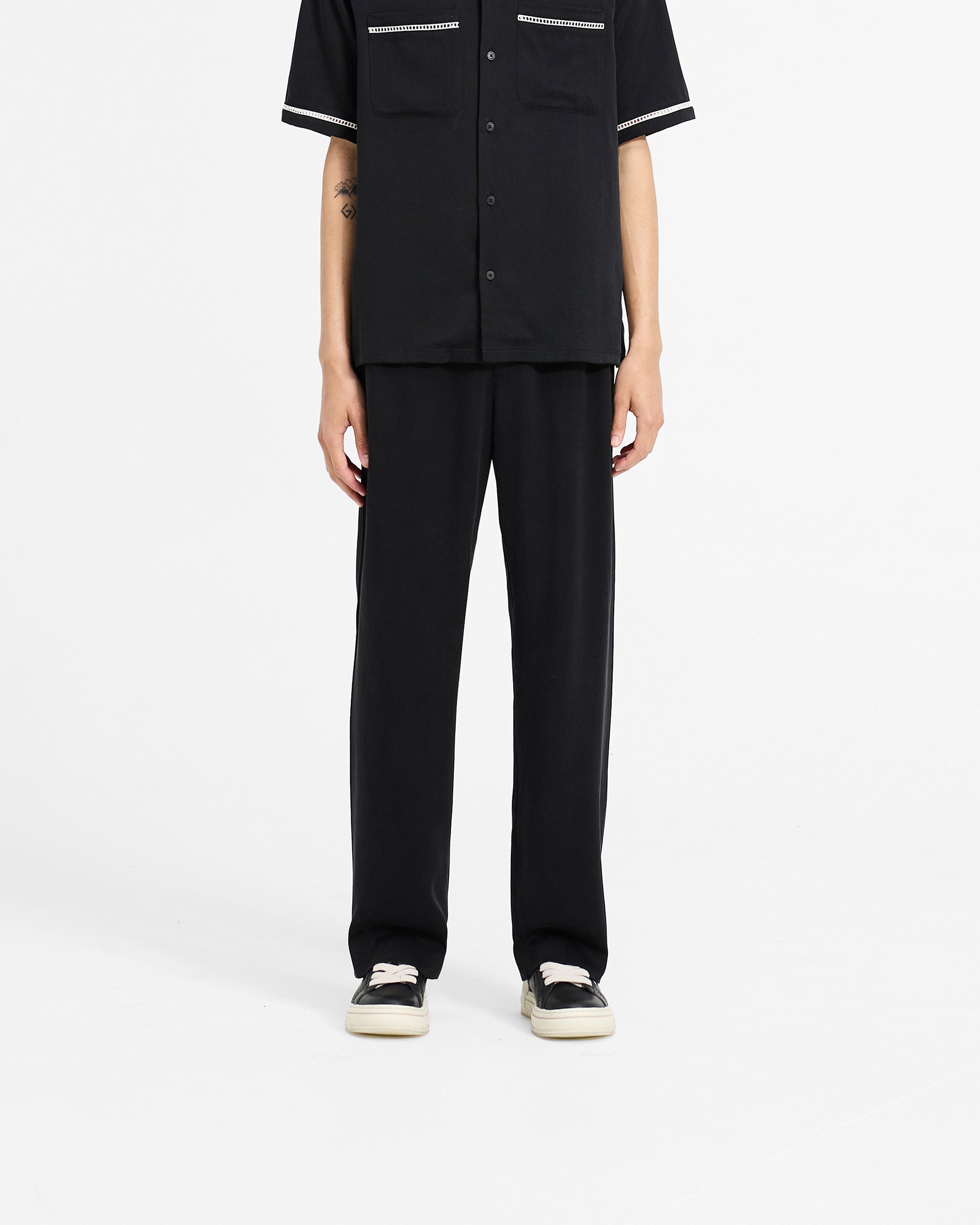 Man wearing black pants on a plain white background | Resort Pant in Jet Black | Straight leg drapey lyocell pants with hybrid waistband | SC24 Pants | Represent Clo