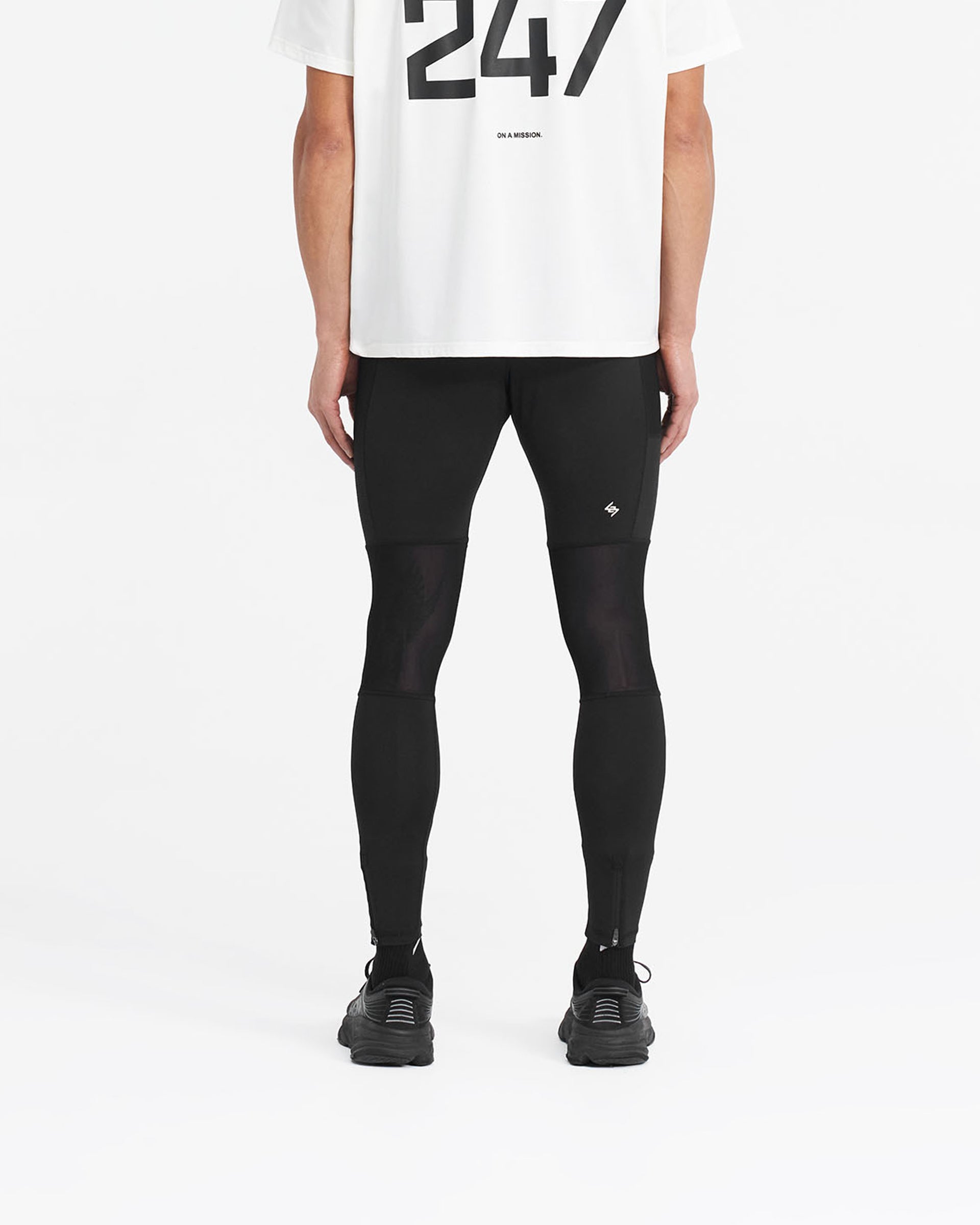Man wearing black running tights on a plain white background | 247 Run Tight in Jet Black | Running tights with stretch ripstop panelling | 247 Pants | Represent Clo
