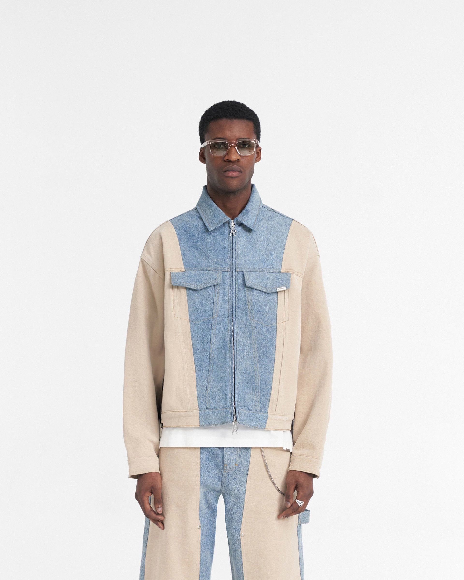 Man wearing a blue denim jacket on a plain white background | R4 Colour Block Denim Jacket in Blue | Luxury boxy fit denim jacket with carpenter panelling | SS24 Denim | Represent Clo