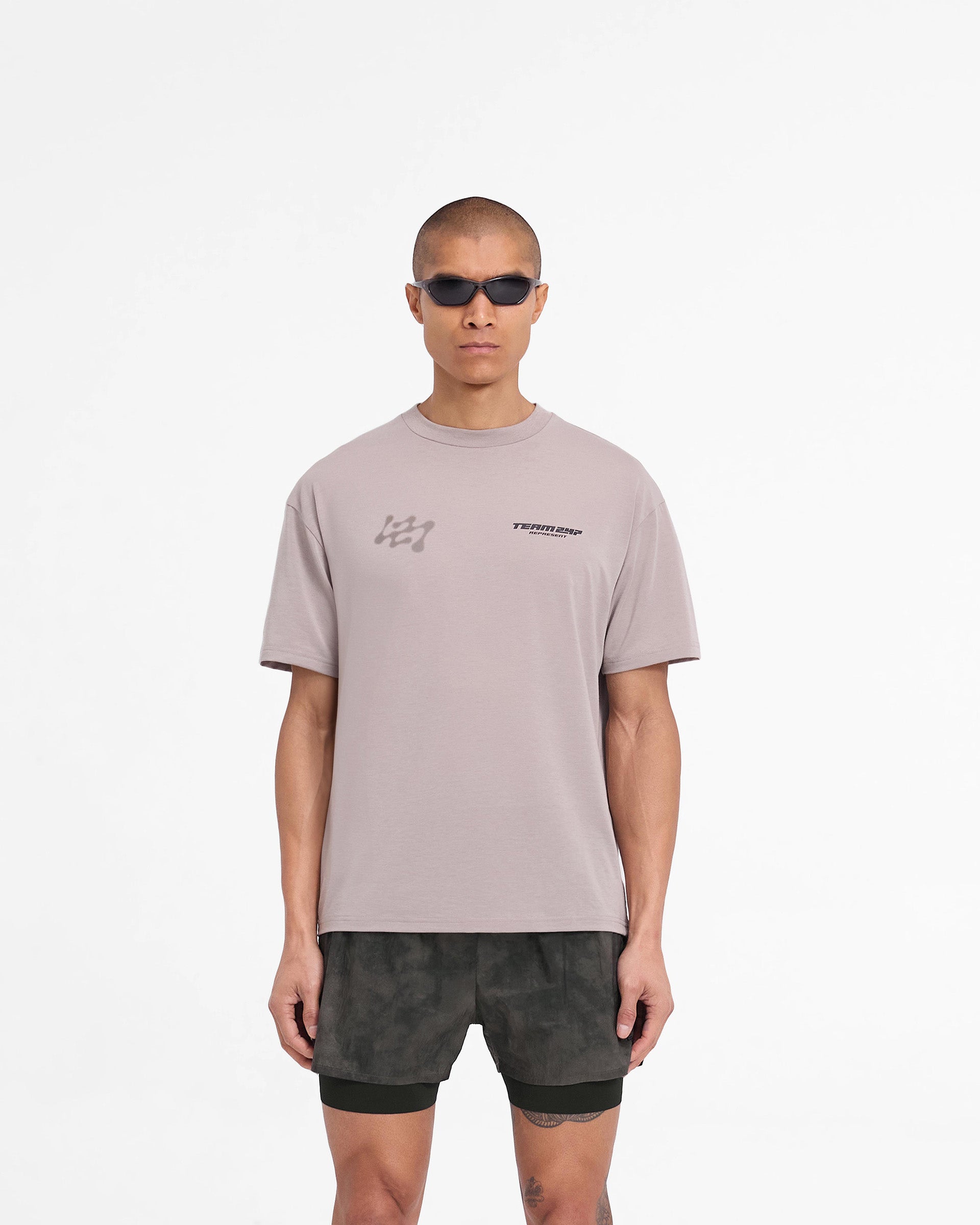 Man wearing a grey oversized t-shirt on a plain white background | 247 Future Terrains Oversized T-Shirt in Moonrock | Quick drying lightweight training t-shirt | 247 T-Shirts | Represent Clo