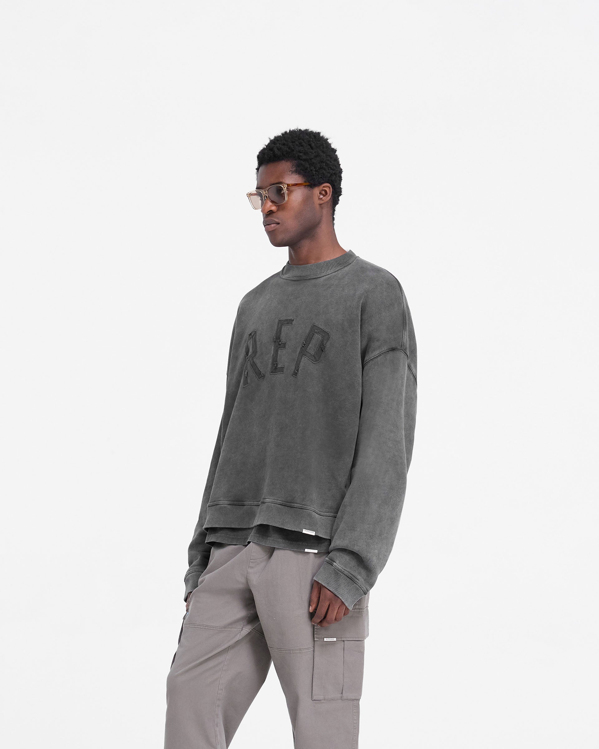 Back product image of a mens black sweater on a plain white background | Rep Applique Sweater in Vintage Black | Oversized heavyweight cotton sweater with ribbed hem and cuffs | FW24 Sweaters | Represent Clo