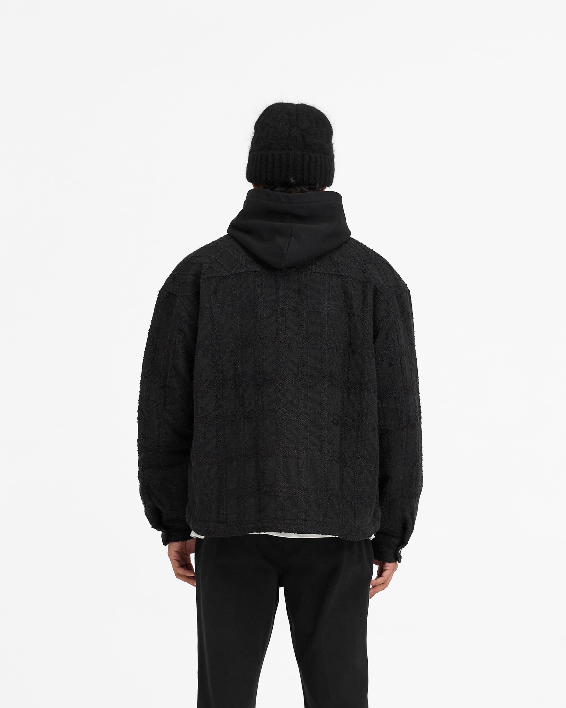 Man wearing a black overshirt on a plain white background | Wadded Overshirt in Black | Slightly oversized overshirt with matte popper closures | FW24 Shirts | Represent Clo