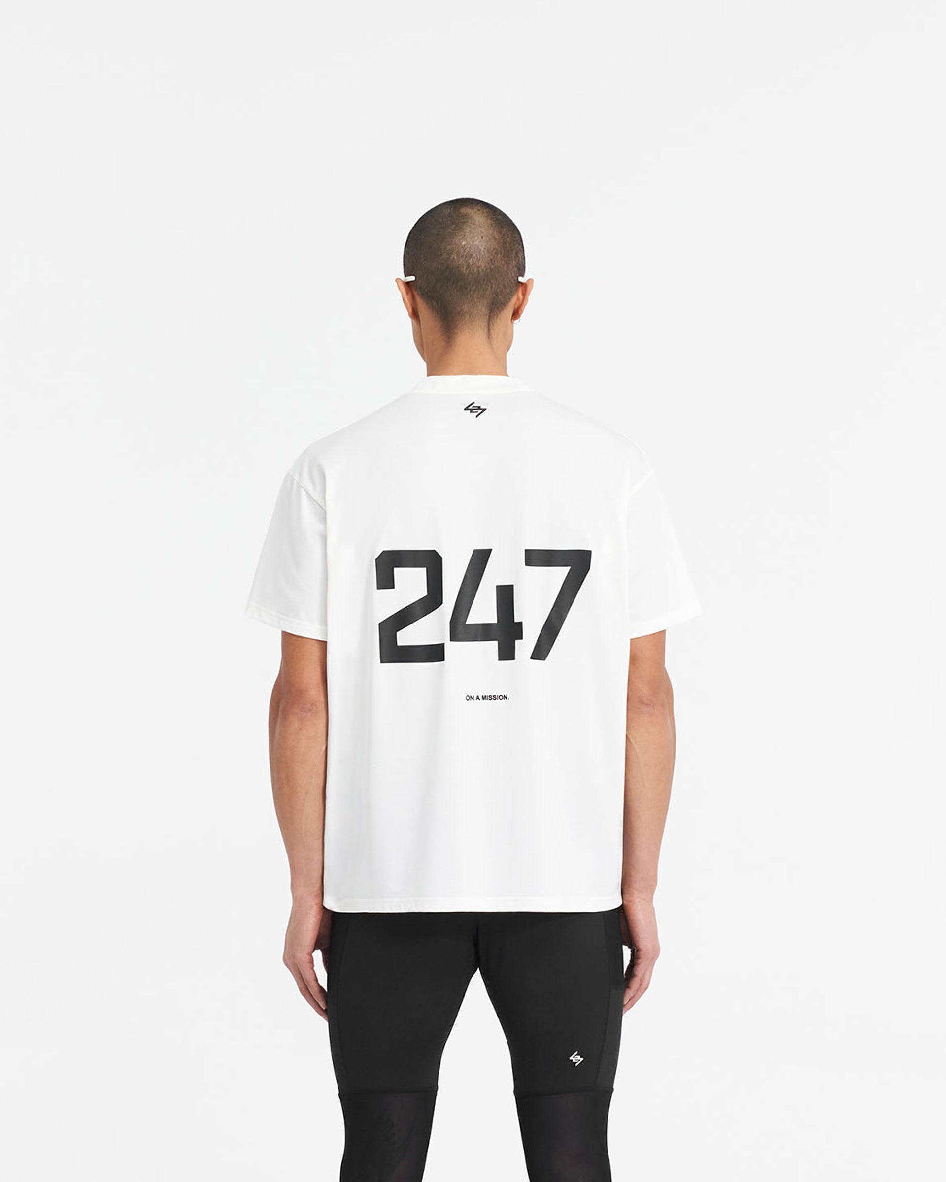 Man wearing an oversized white t-shirt on a plain white background | 247 Oversized T-Shirt in Flat White | Quick dry gym t-shirt with 4-way stretch | 247 T-Shirts | Represent Clo