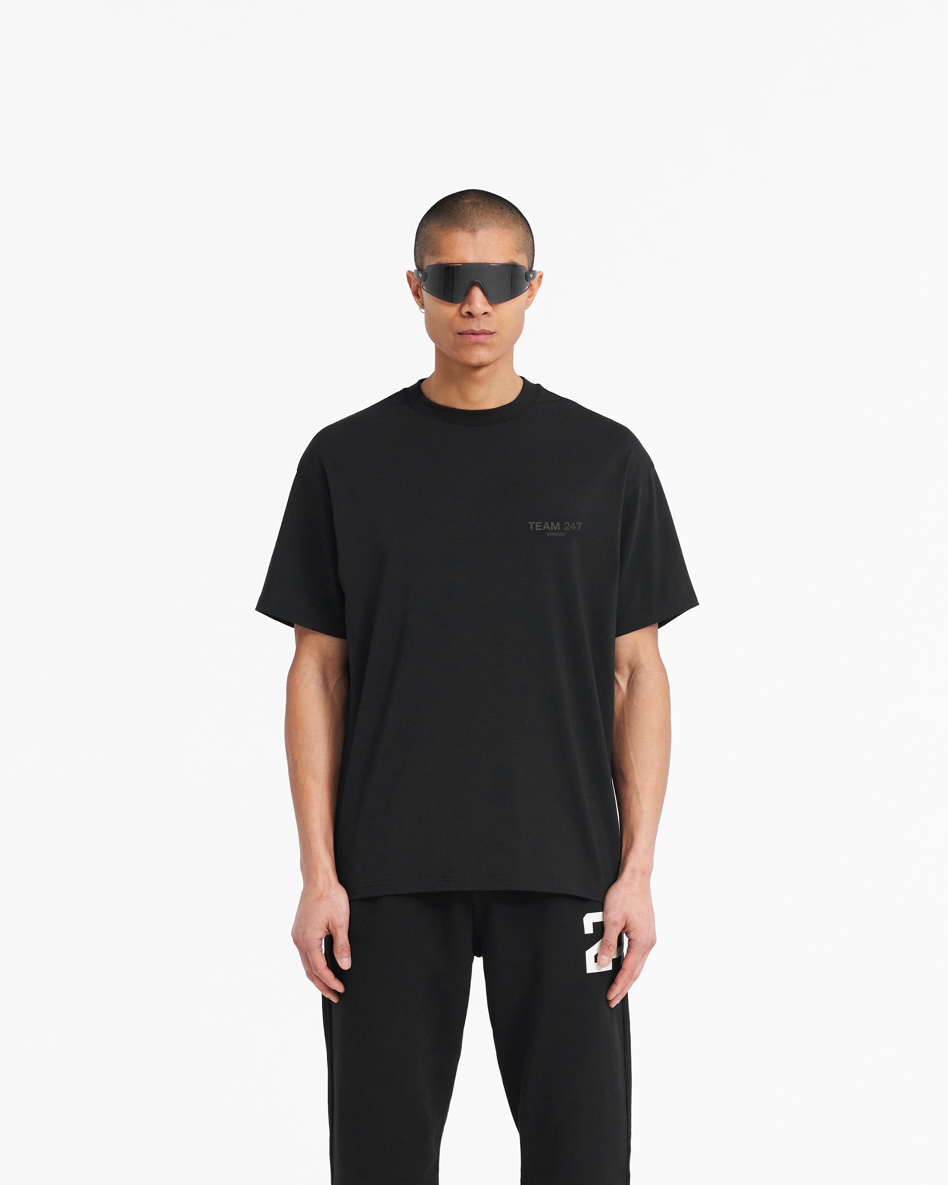 Man wearing an oversized black t-shirt on a plain white background | Team 247 Oversized T-Shirt in Matte Black | Lightweight gym top with 4-way stretch | 247 T-Shirts | Represent Clo