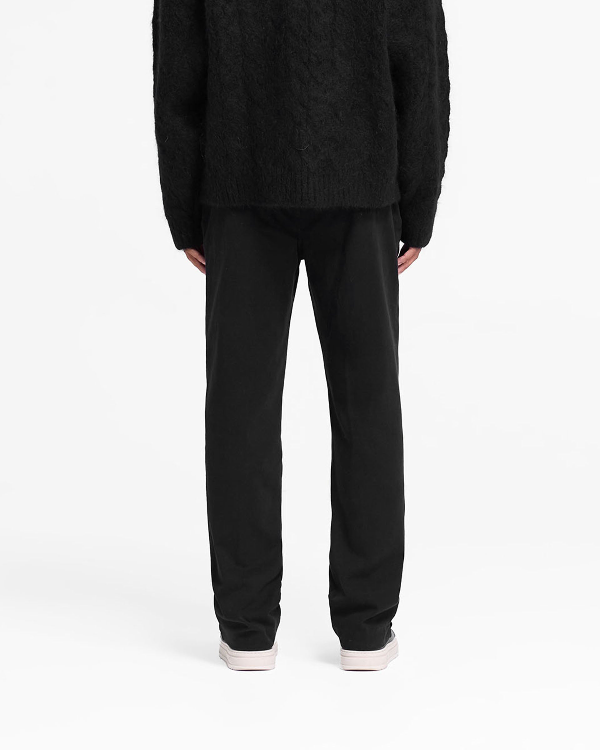 Man wearing a black pant on a plain white background | Cotton Pant in Black | Straight leg cotton twill pants with side and back pockets | FW24 Pants | Represent Clo