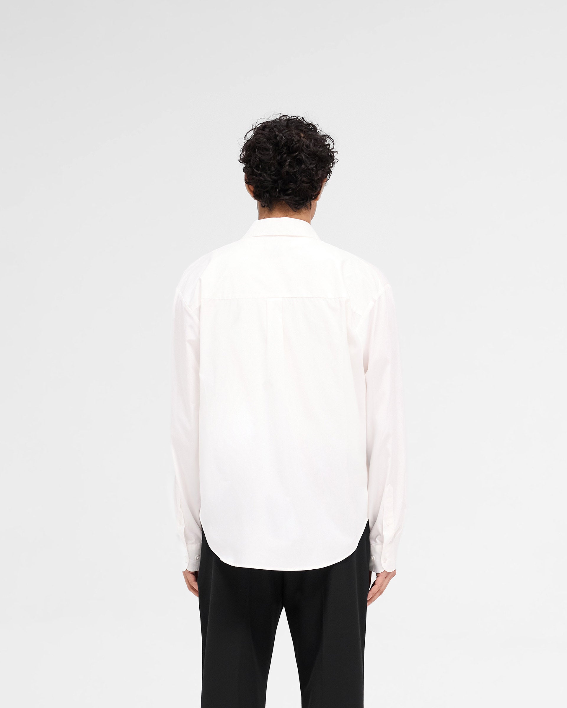 Man wearing an off white shirt on a plain white background | Raceway Shirt in Off White | Oversized fit shirt with concealed button placket and raceway artwork | SS25 Shirts | Represent Clo