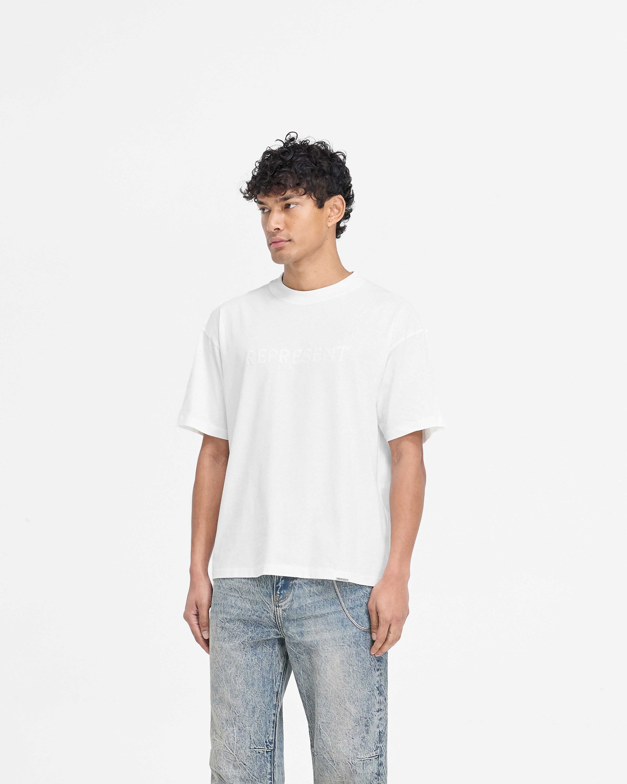 Back product image of a mens white t-shirt on a plain white background | Serif Logo T-Shirt in Flat White | Oversized t-shirt with embroidered branding | PRE SS25 T-Shirts | Represent Clo