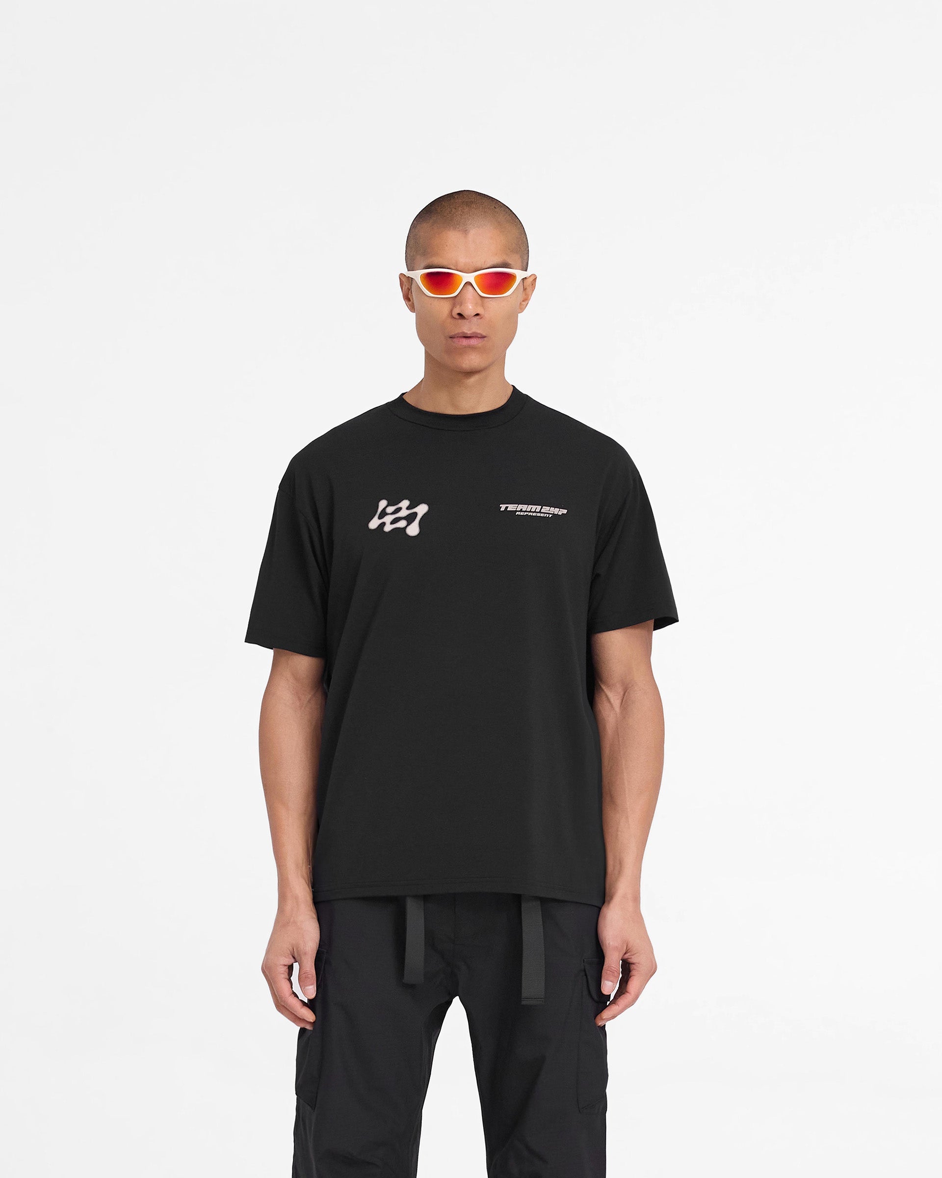 Man wearing a black t-shirt on a plain white background | 247 Future Terrains Oversized T-Shirt in Black | Oversized quick drying training t-shirt | 247 T-Shirts | Represent Clo