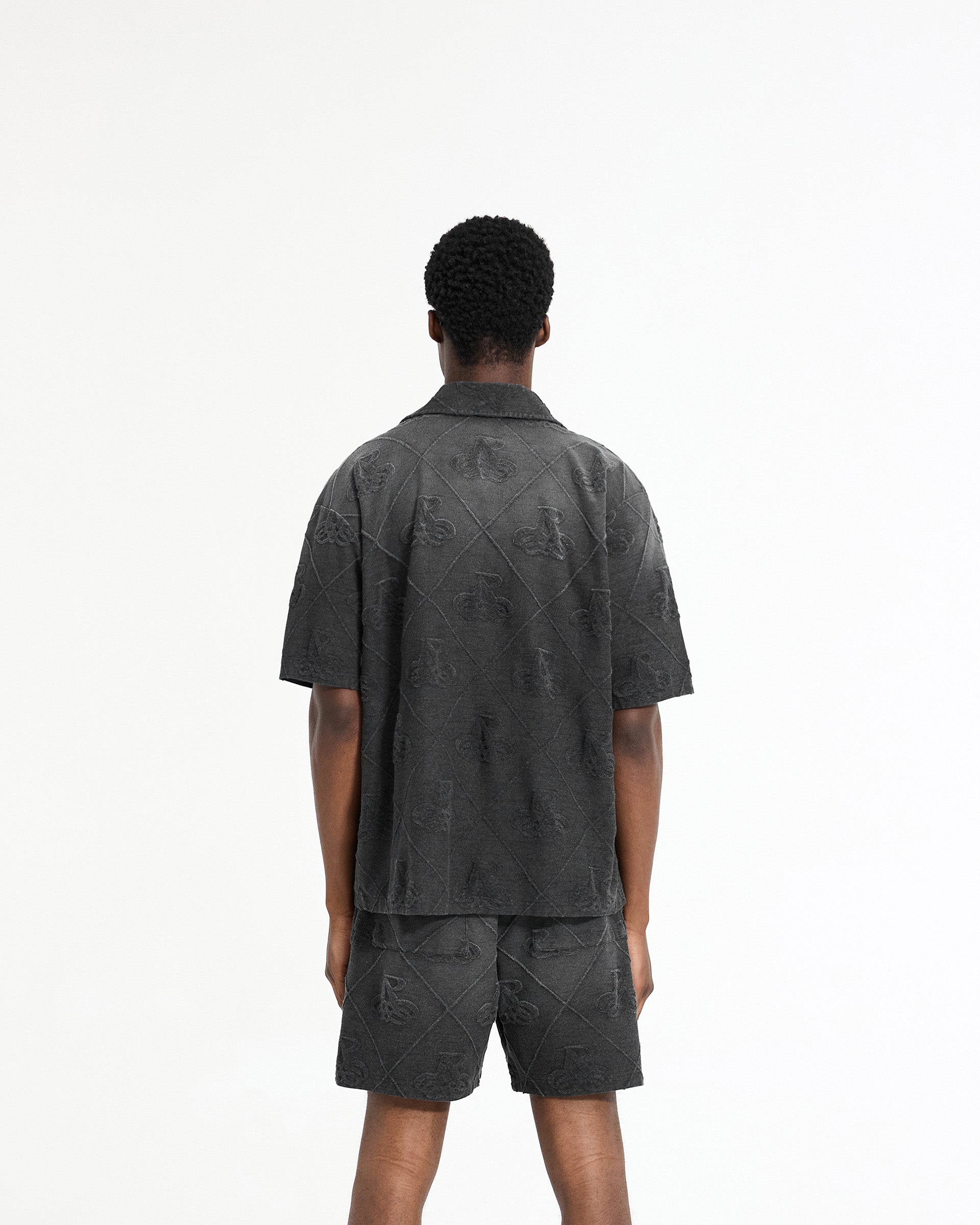 Man wearing a black shirt on a plain white background | Towelling Shirt in Jet Black | Oversized shirt with popper fastenings | SC24 Shirts | Represent Clo