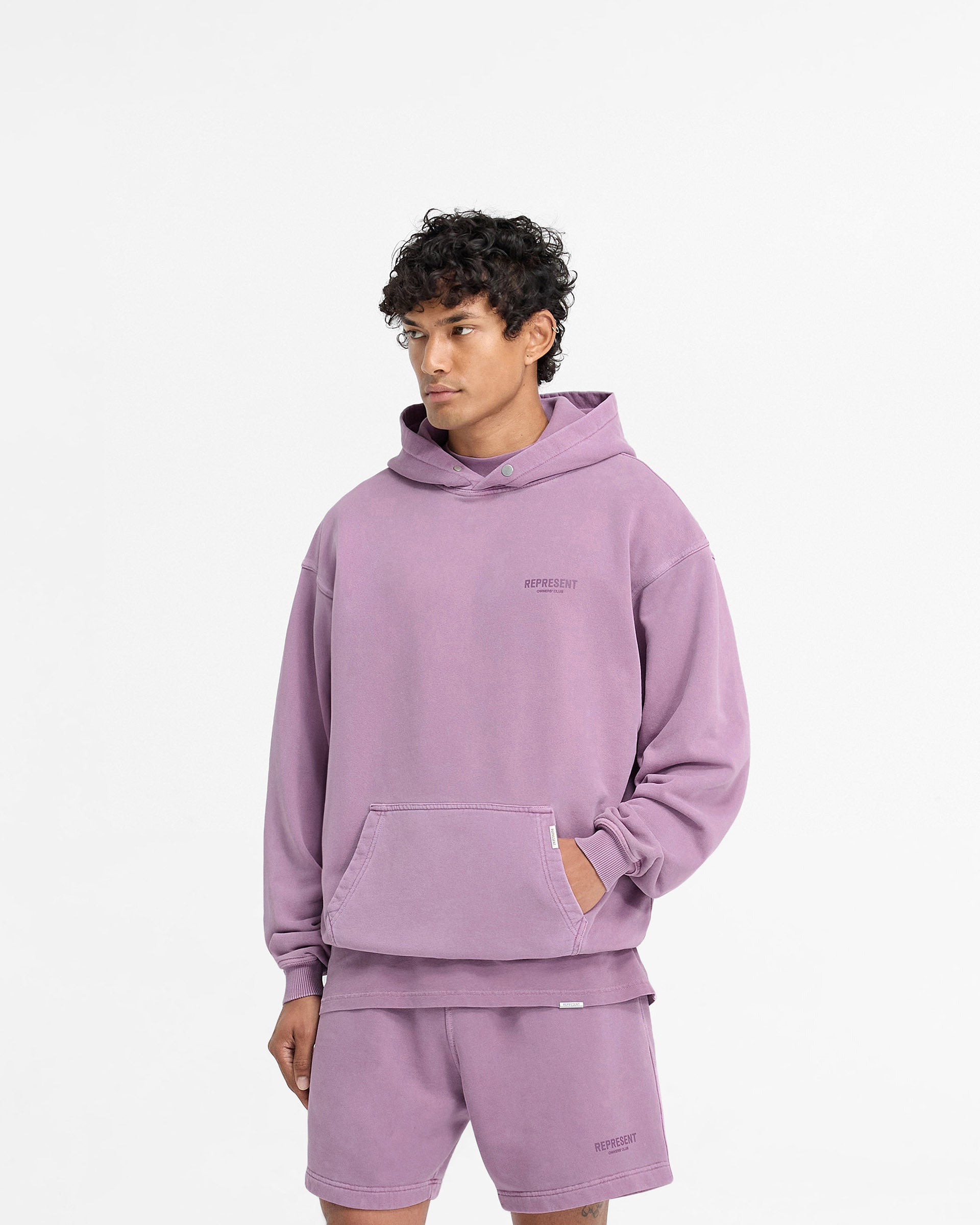 Man wearing a purple hoodie on a plain white background | Represent Owners Club Hoodie in Mid Purple | Oversized fit hoodie with ribbed trims | Owners Club Hoodies | Represent Clo