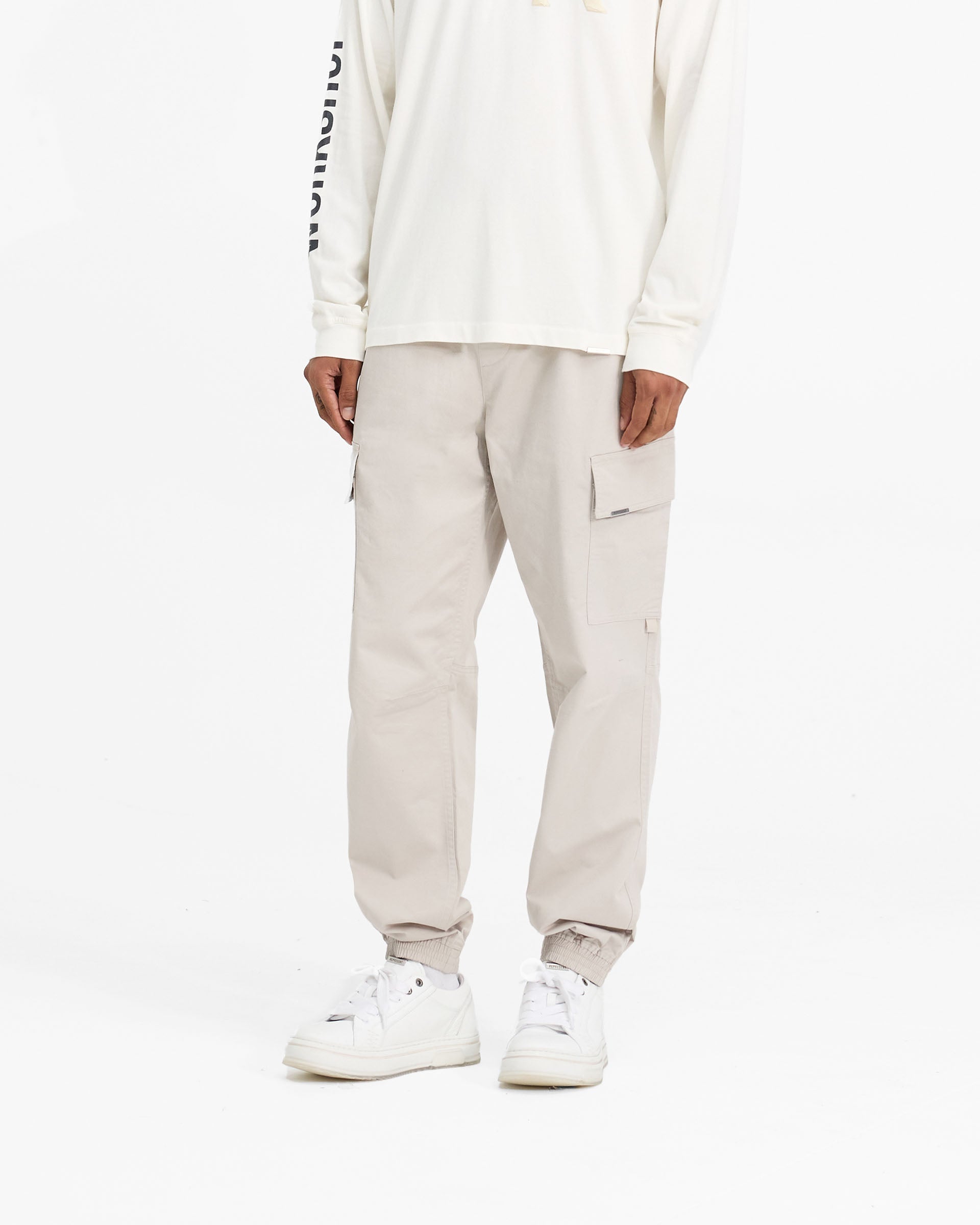 Back product image of mens stone cargo pants on a plain white background | Cuffed Cargo Pant in Stone | Cargo pants with elasticated waistband and cuffs | FW24 Pants | Represent Clo