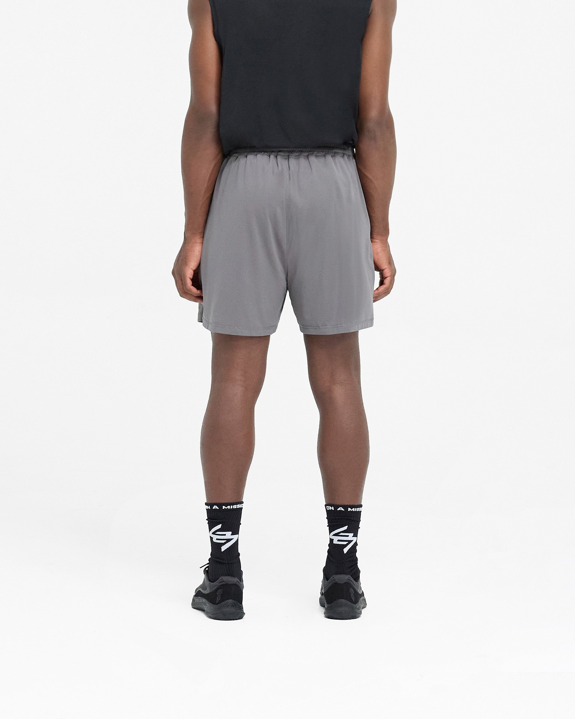 Man wearing oversized grey training shorts on a plain white background | 247 Mesh Shorts in Pewter | Mesh shorts with zip pockets and side split hem | 247 Shorts | Represent Clo