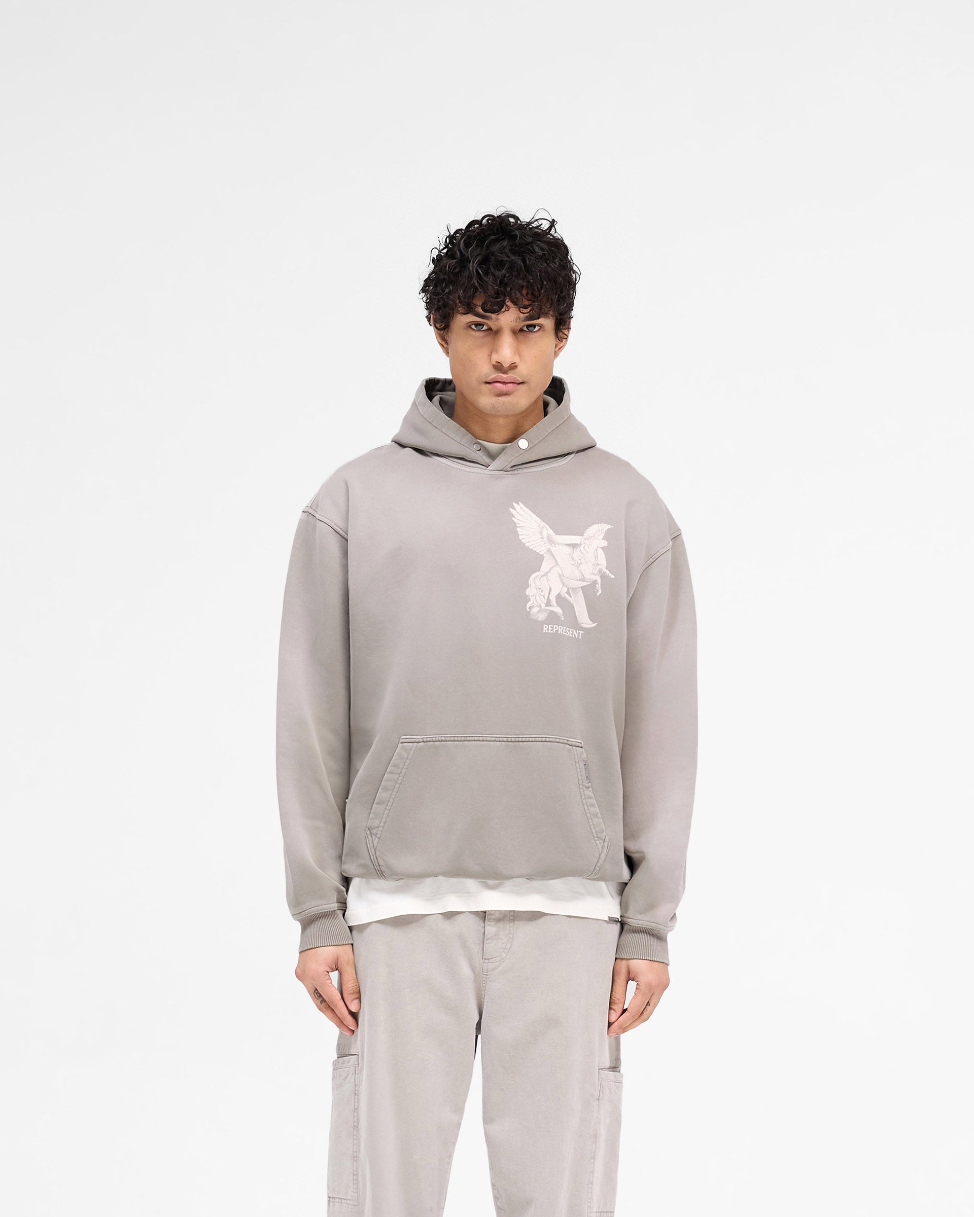 Man wearing an oversized grey hoodie on a plain white background | Elegance In Motion Hoodie in Thunder | Heavyweight cotton hoodie with graphic and popper fastening | SS25 Hoodies | Represent Clo