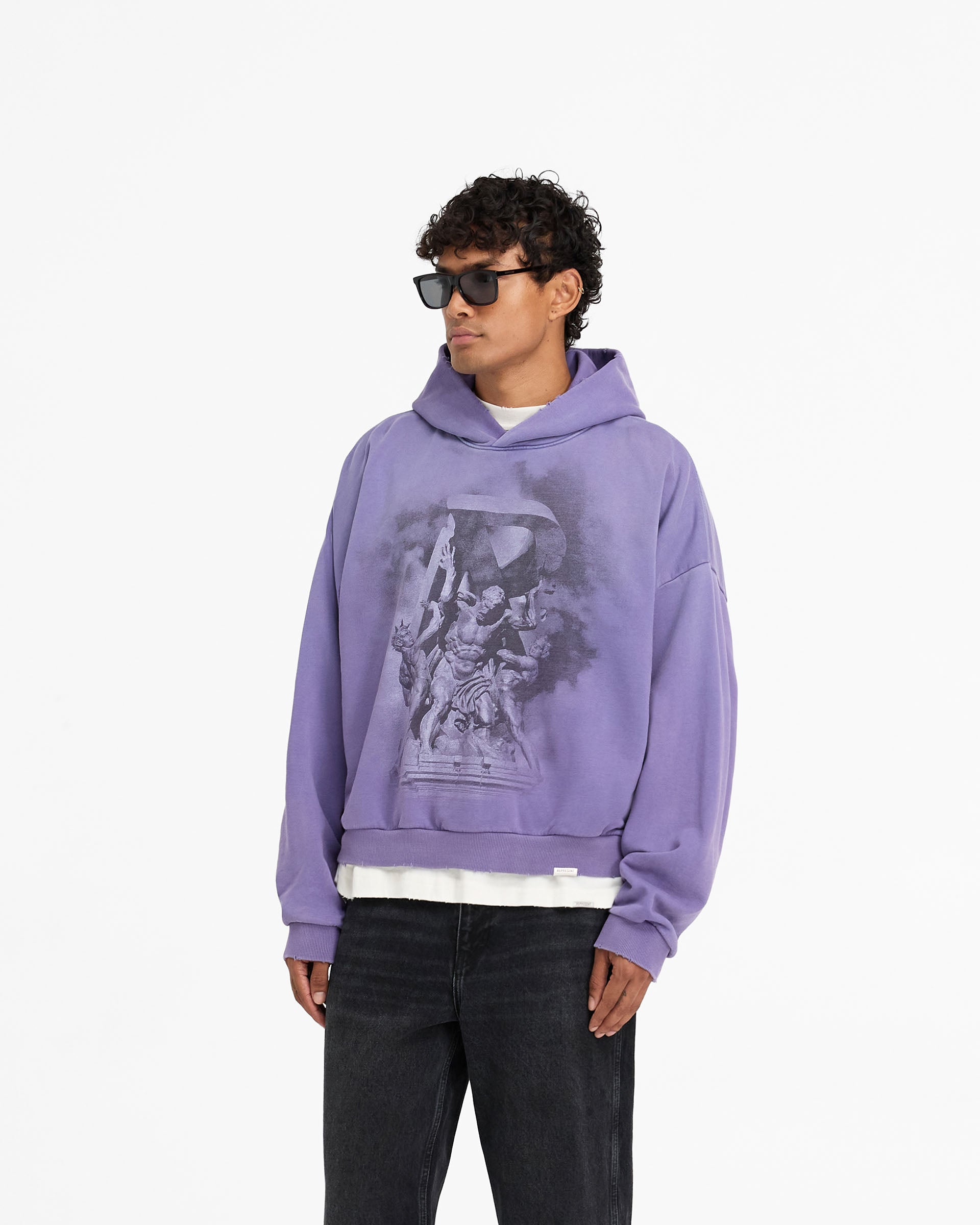 Man wearing a purple hoodie on a plain white background | Atlas Hoodie in Purple | Oversized boxy fit hoodie with screen print graphics | FW24 Hoodies | Represent Clo
