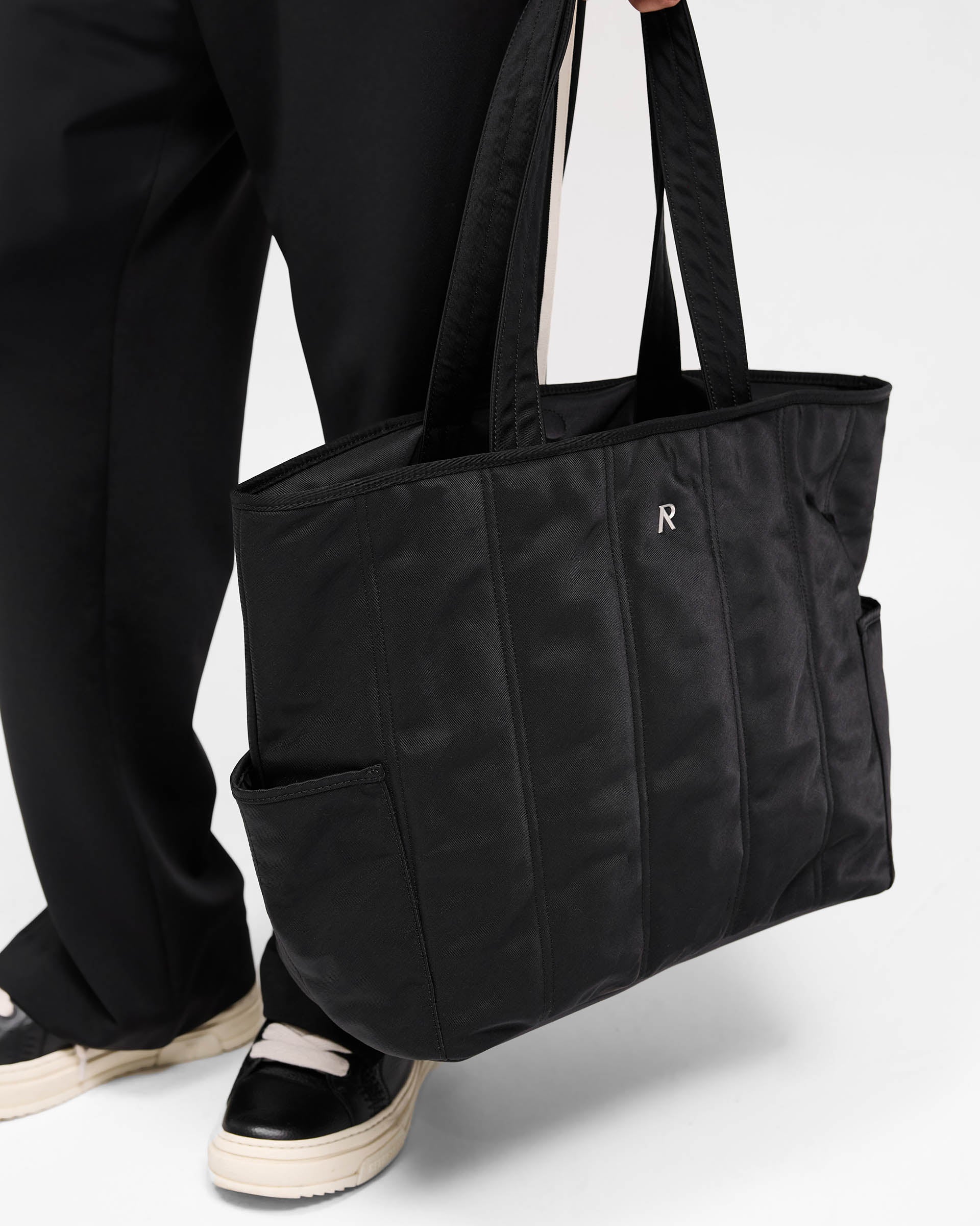 Back product image of a mens black tote bag on a plain white background | Quilted Tote Bag in Jet Black | Nylon bag with quilted panels and magnetic closure | SS25 Accessories | Represent Clo