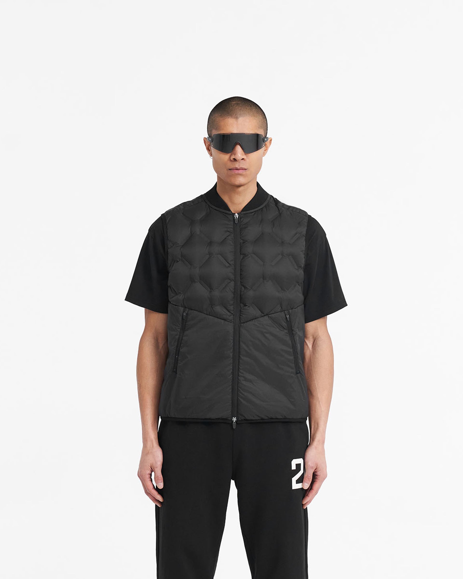 Man wearing a black gilet on a plain white background | 247 Lightweight Gilet in Black | Nylon gilet with bomber collar and mesh ventilation | 247 Outerwear | Represent Clo