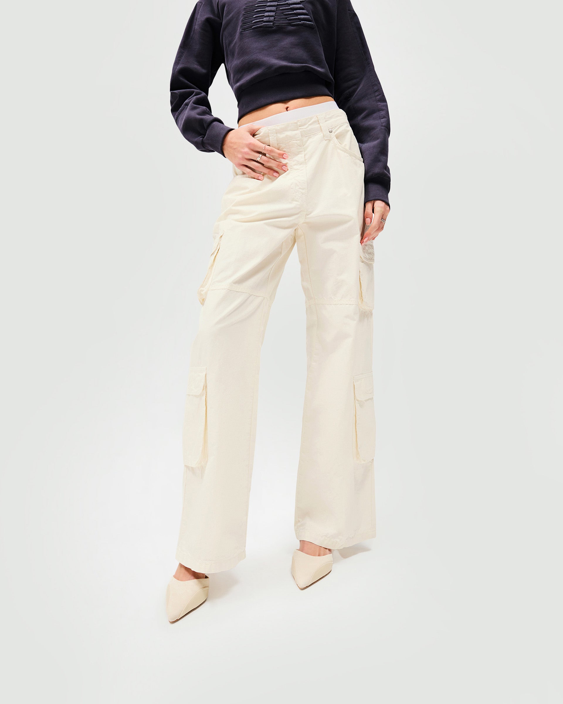 Woman wearing antique white cargo pants on a plain white background | Fender Cargo in Antique White | Cargo pants with ripstop cotton and wide legs | Womens SS25 Bottoms | Represent Clo