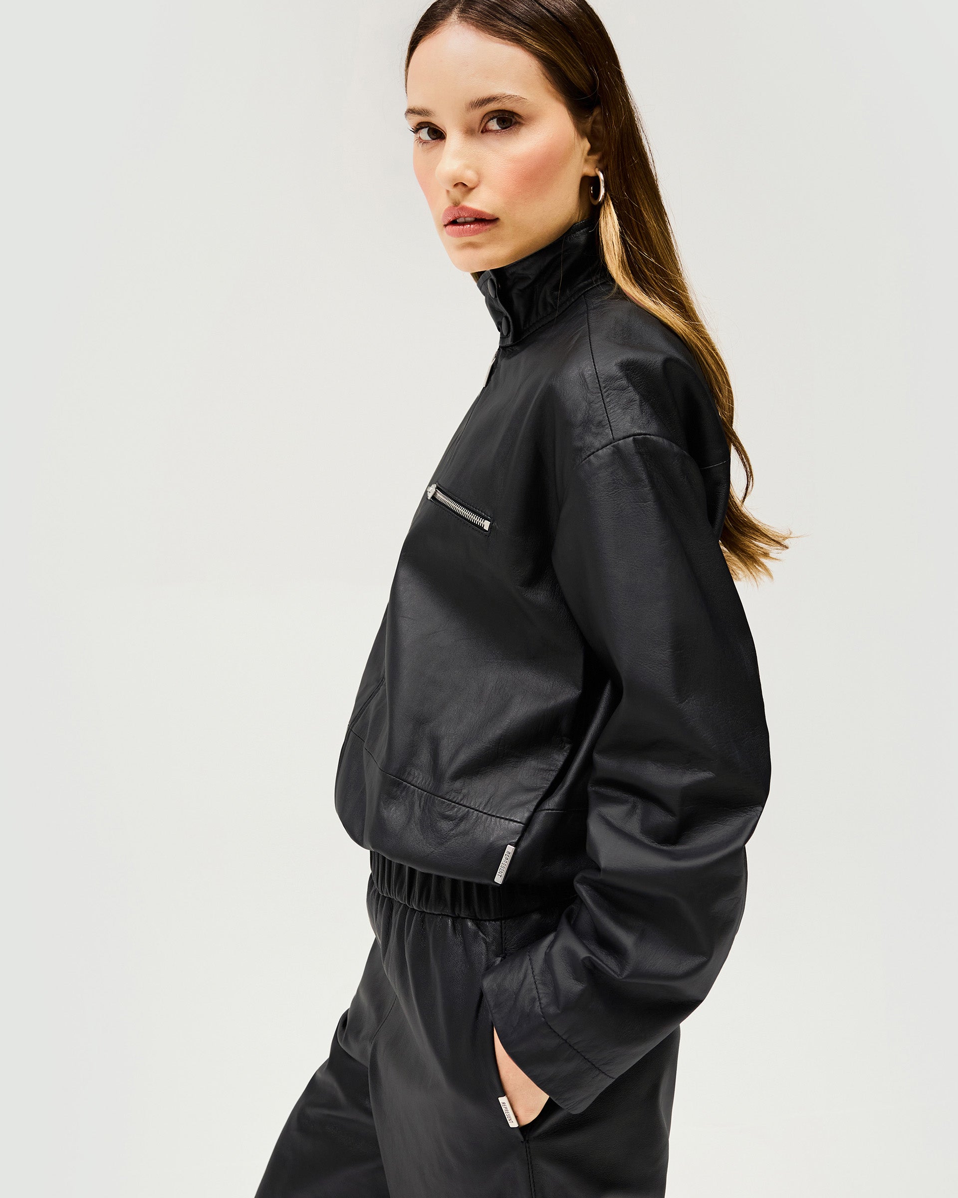Back product image of a womens black leather jacket on a plain white background | Fuel Jacket in Jet Black | Leather jacket with elasticated gathered hem and 2 way zip | Womens SS25 Outerwear | Represent Clo