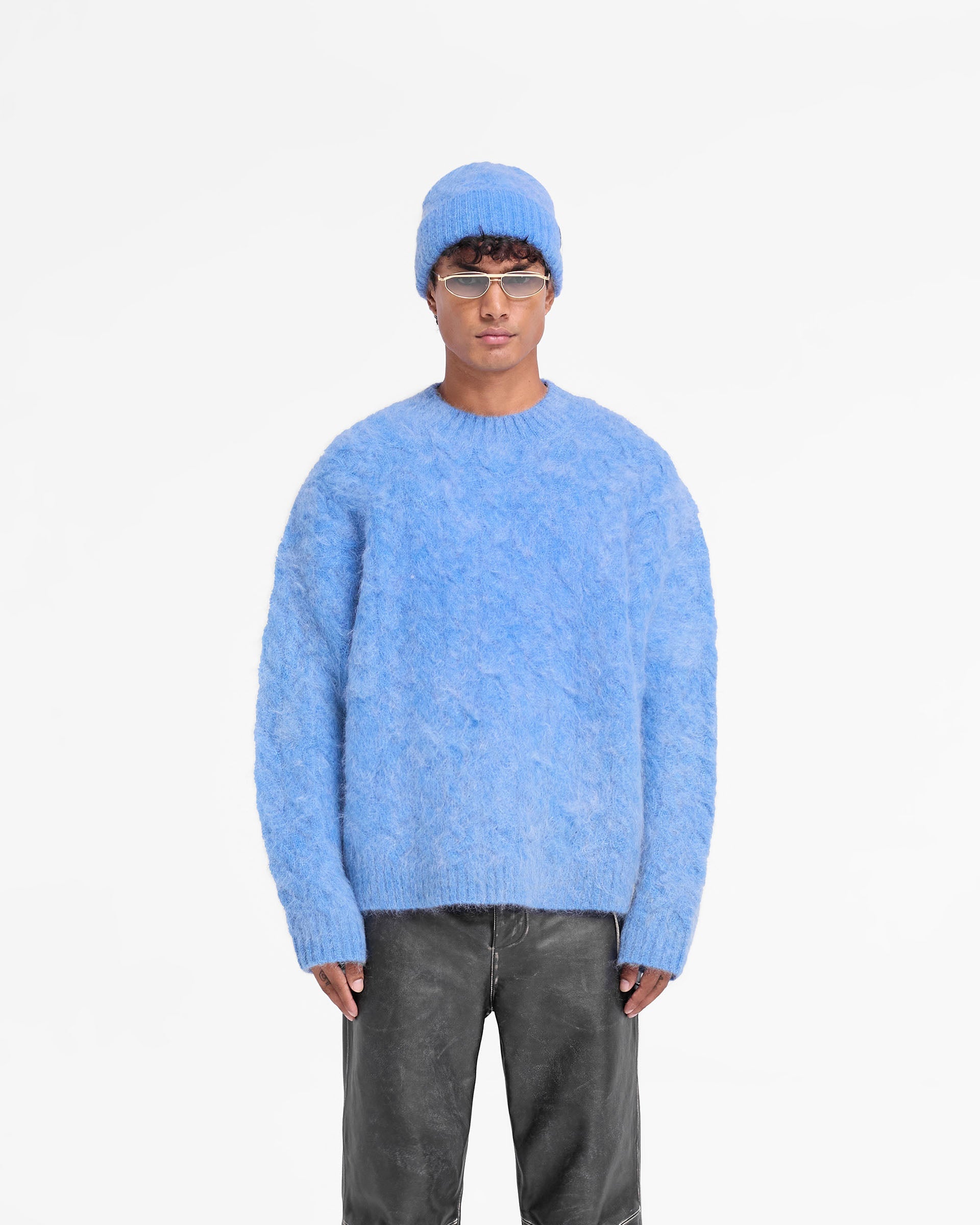 Man wearing an electric blue cable knit sweater on a plain white background | Cable Knit Sweater in Electric Blue | Very oversized mohair jumper with ribbed hem, cuffs, and collar | FW24 Knitwear | Represent Clo