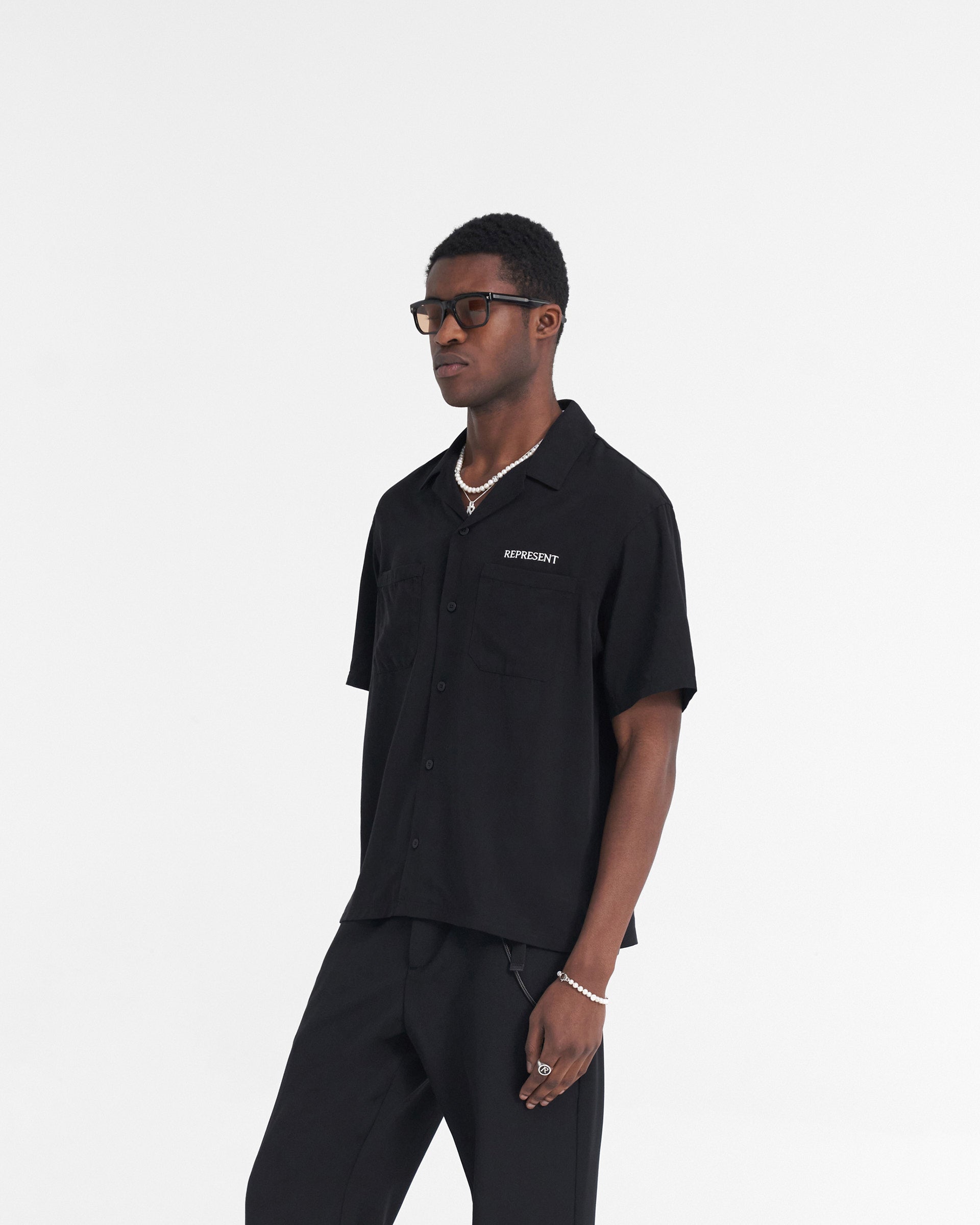 Back product image of a mens black shirt on a plain white background | Bowling Shirt in Black | Lightweight woven black shirt with tonal buttons | SS24 Shirts | Represent Clo