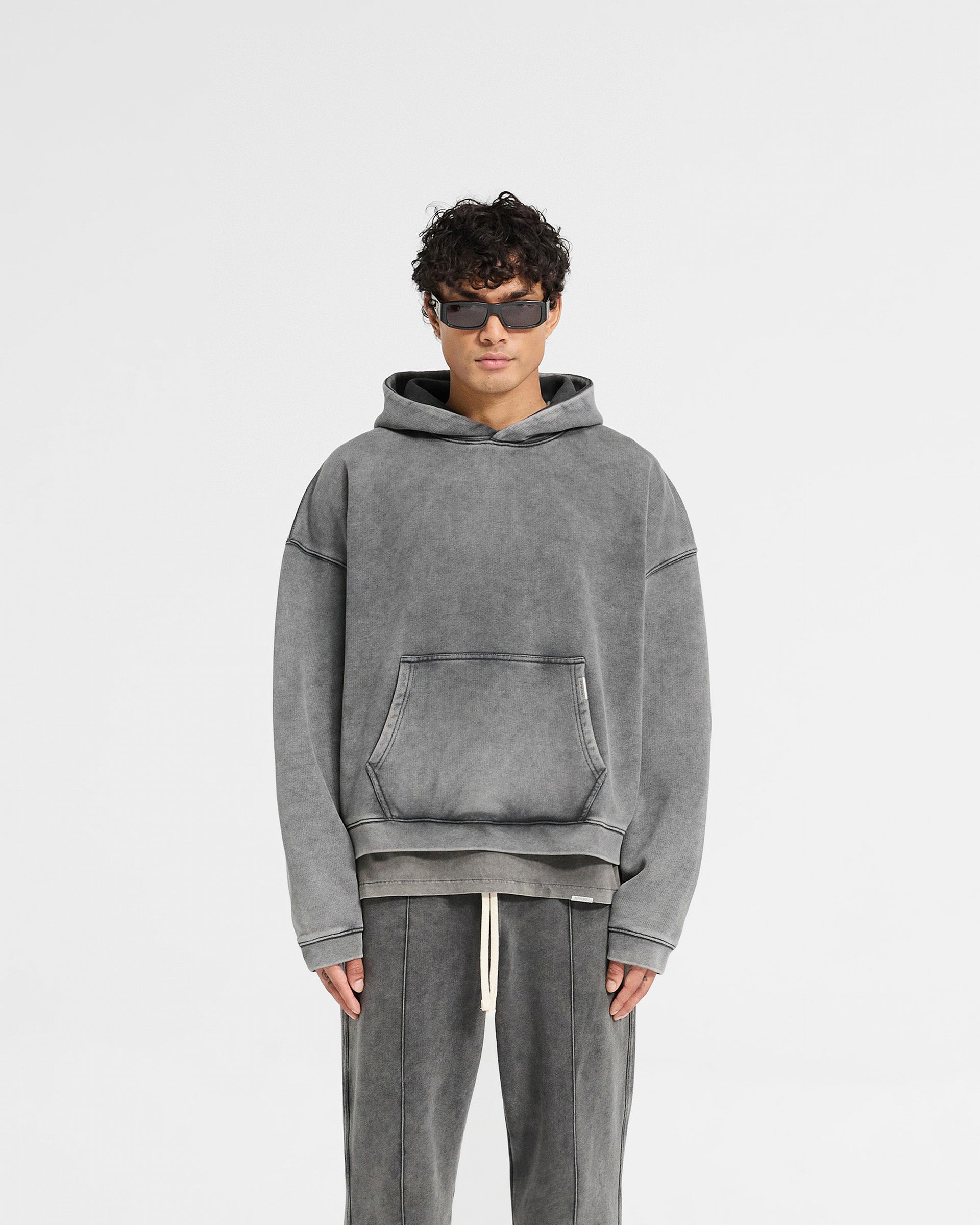 Man wearing an oversized grey hoodie on a plain white background | Initial Boxy Hoodie in Vintage Grey | Oversized boxy hoodie with cropped body and dropped shoulders | Initial Hoodies | Represent Clo