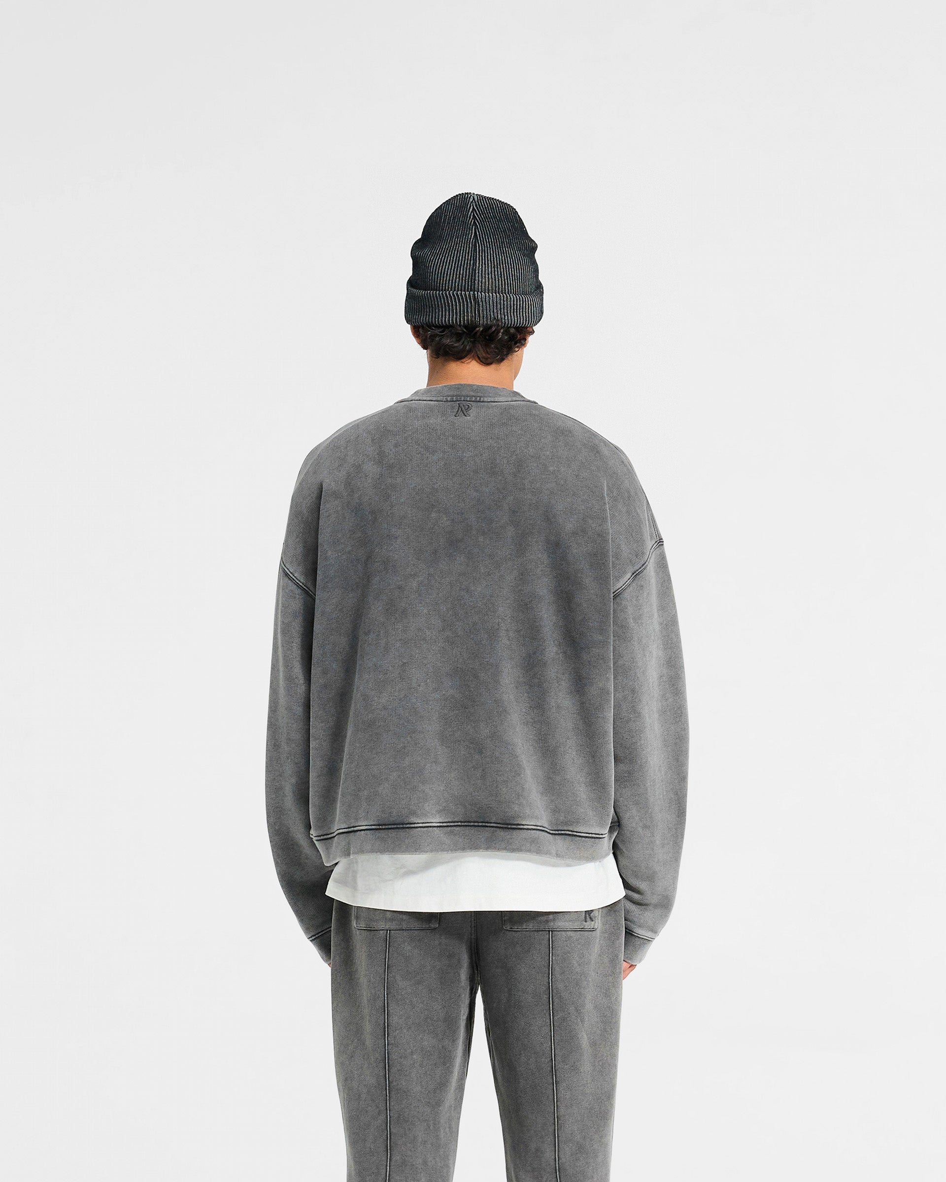 Man wearing a grey oversized boxy sweater on a plain white background | Initial Boxy Sweater in Vintage Grey | Cropped fit with dropped shoulders and brushed fleece cotton | Initial Sweaters | Represent Clo