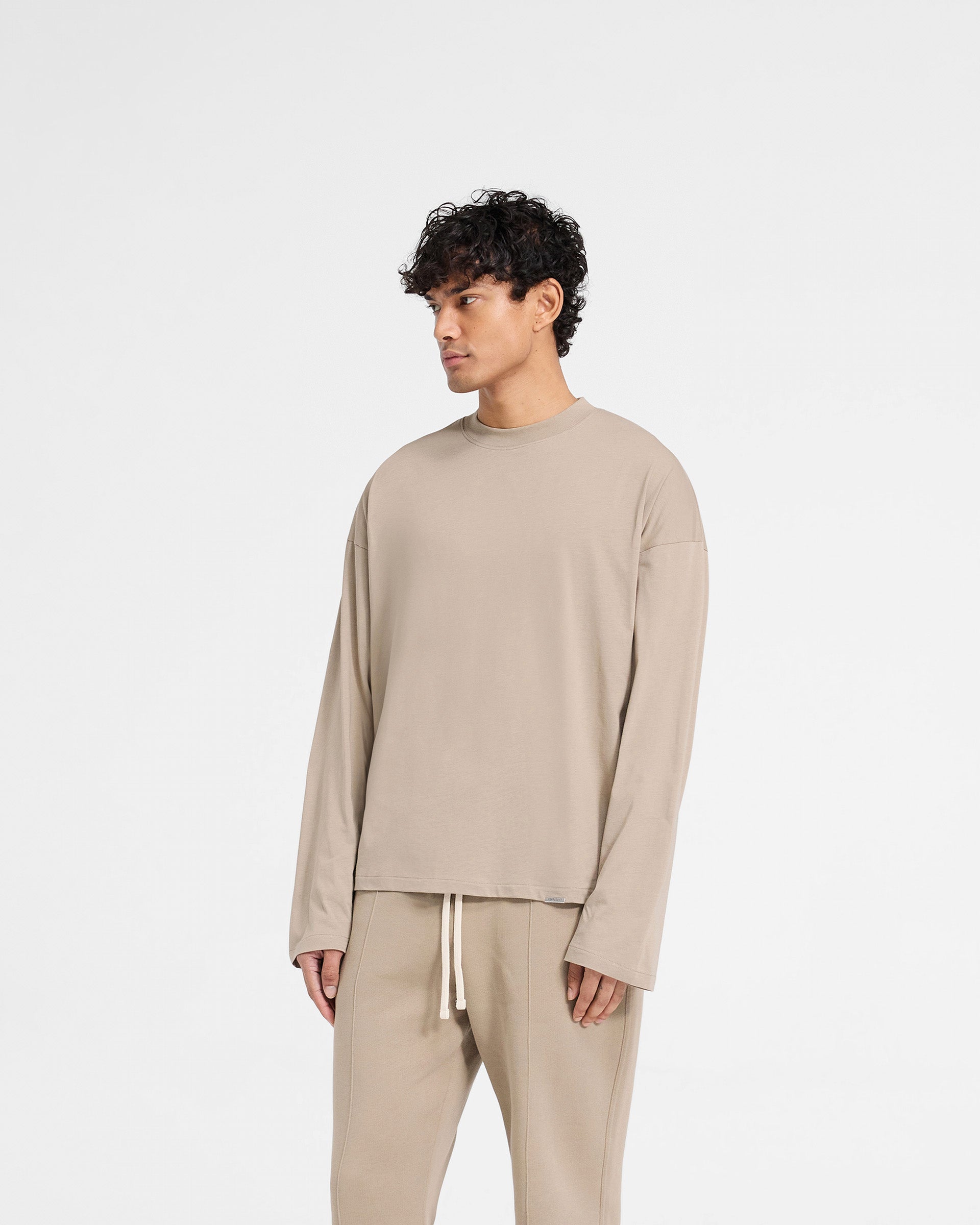 Back product image of a mens beige t shirt on a plain white background | Initial Long Sleeve Open Cuff T-Shirt in Dune | Oversized t shirt with open cuffs | Initial T-Shirts | Represent Clo