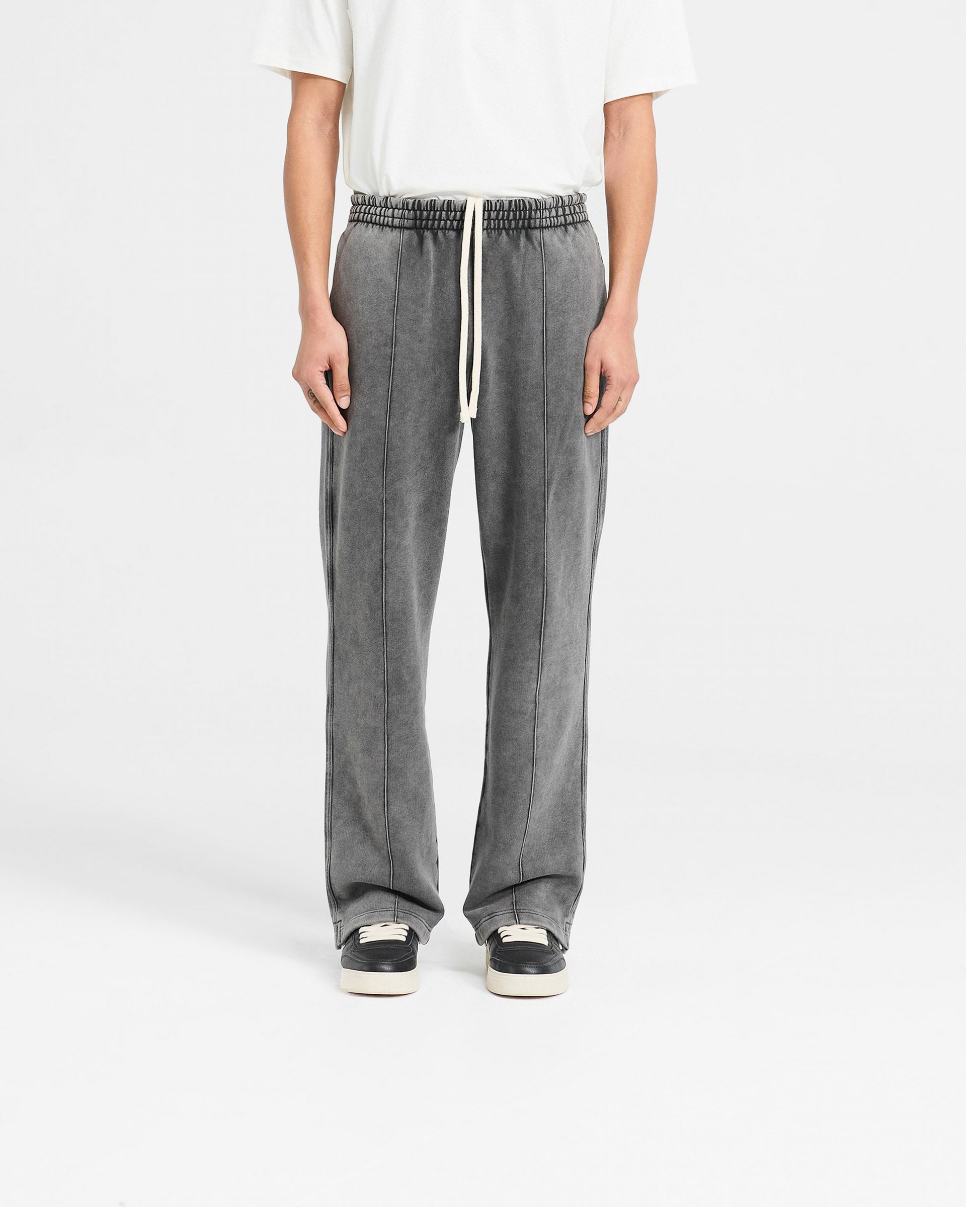 Man wearing vintage grey sweatpants on a plain white background | Initial Sweatpants in Vintage Grey | Wide leg sweatpants with split hem | Initial Pants | Represent Clo