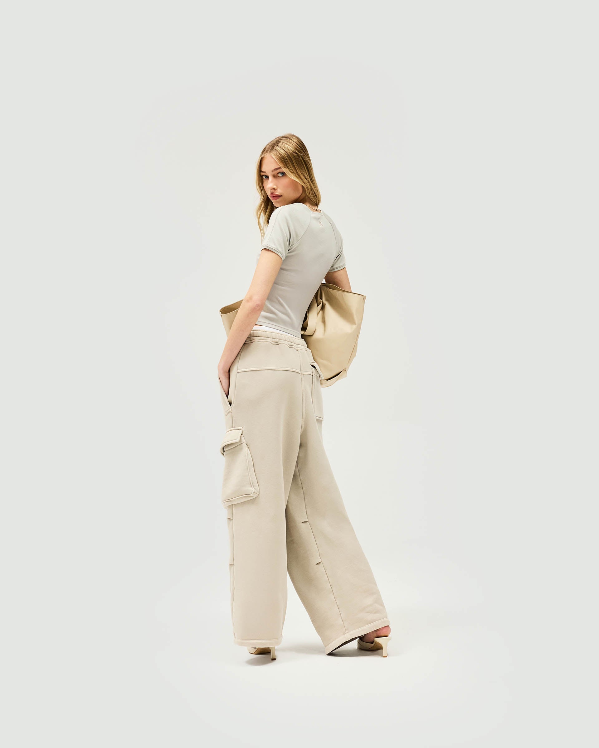 Woman wearing grey cargo joggers on a plain white background | Initial Cargo Jogger in Storm | Heavyweight cotton cargo joggers with patch pockets | Womens Initial Bottoms | Represent Clo