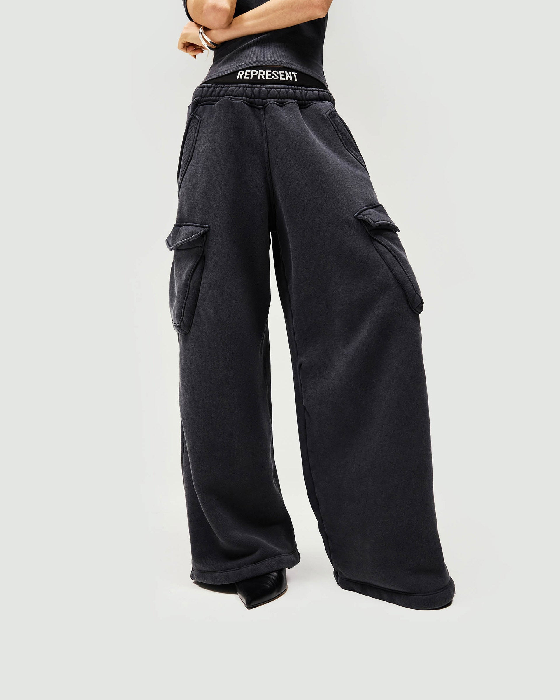 Woman wearing black cargo jogger on a plain white background | Initial Cargo Jogger in Washed Black | Heavyweight cotton cargo jogger with patch pockets | Womens Initial Bottoms | Represent Clo